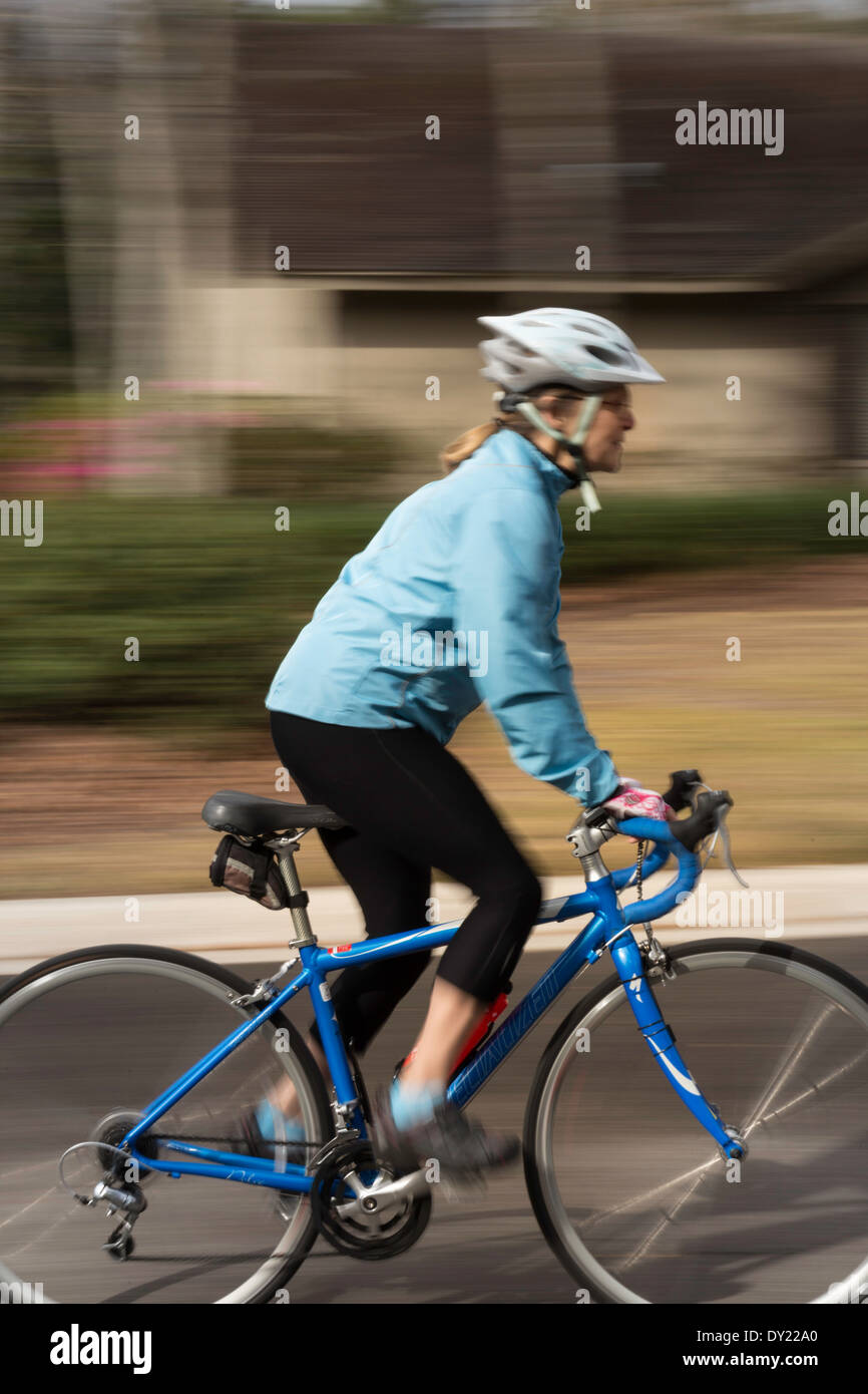 Mature Female Cyclist Accelerates Her Bike in Standing Position, USA Stock Photo