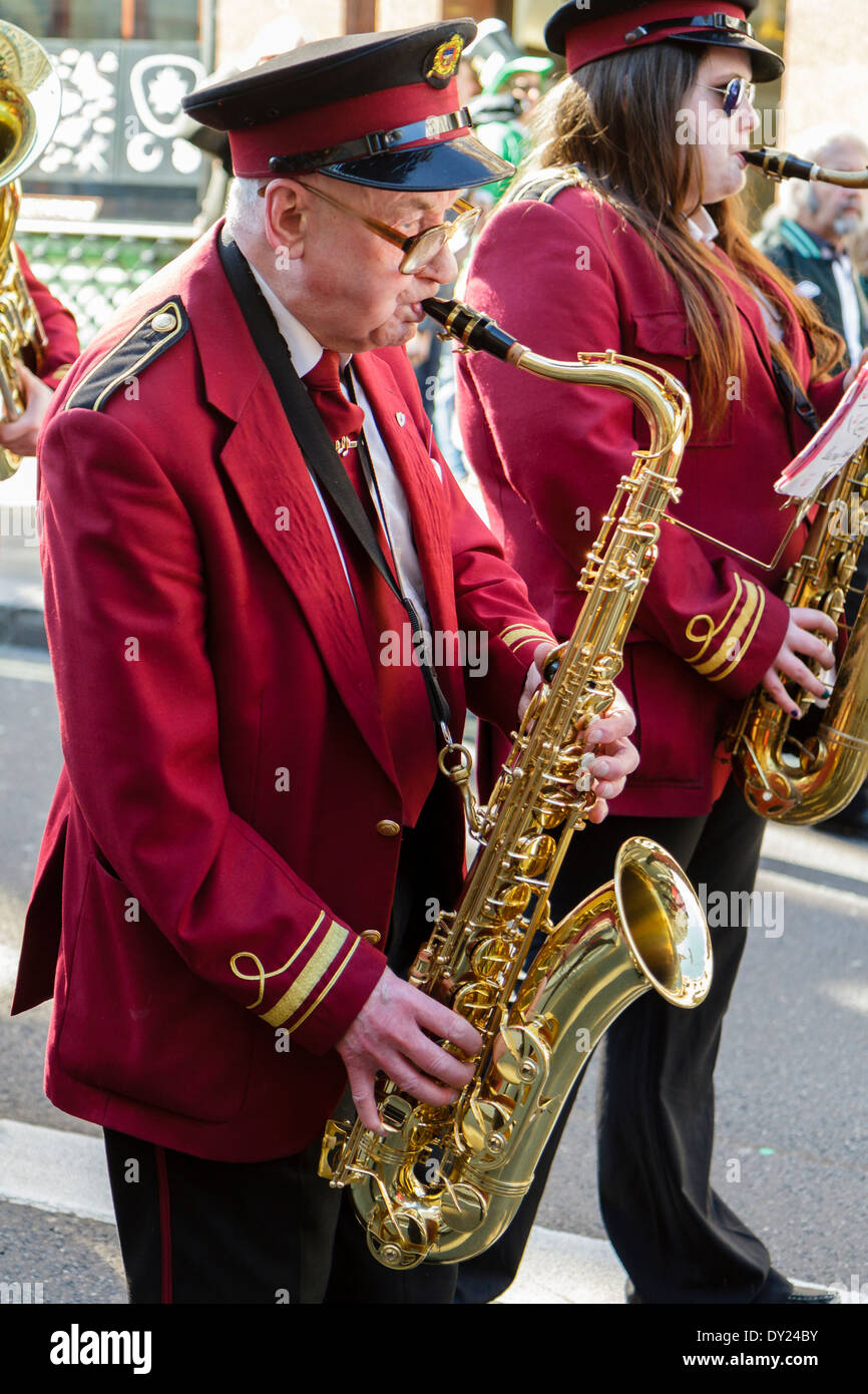 Elderly man playing saxophone in marching band, London UK Stock Photo