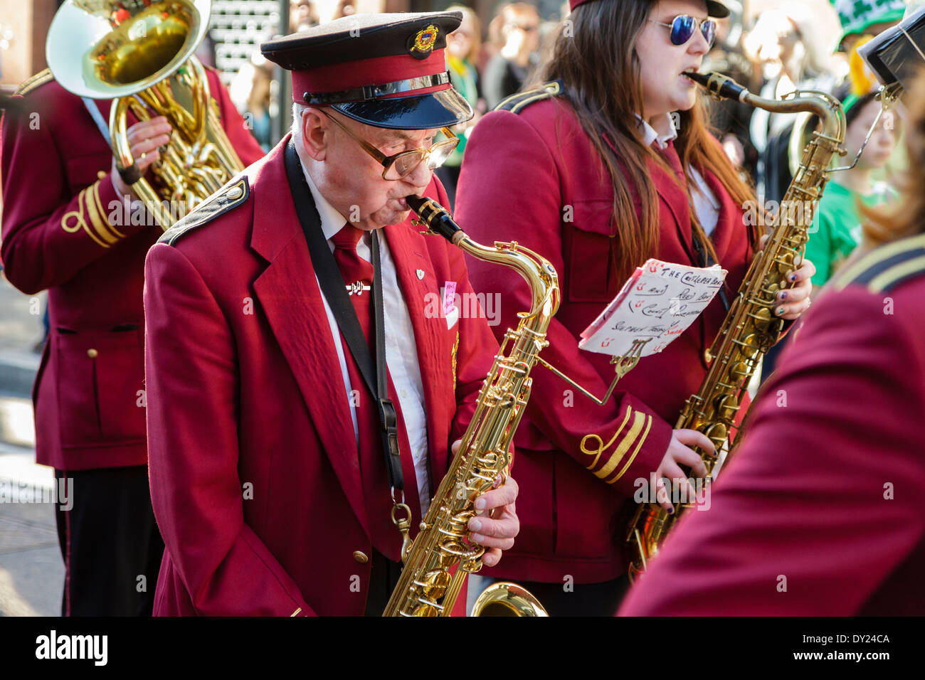 Elderly man playing saxophone in marching band, London UK Stock Photo