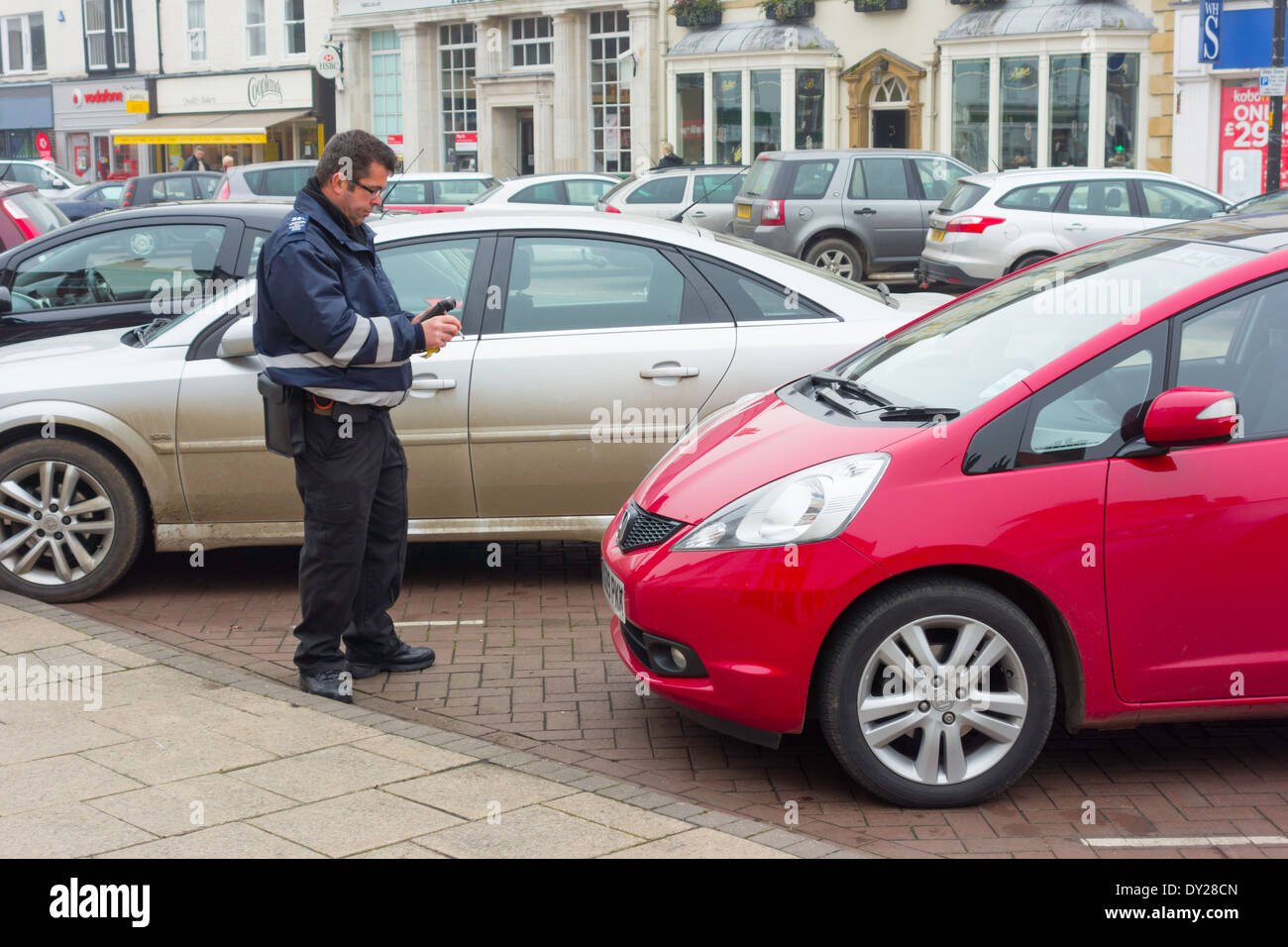 Parking attendant checking the arrival time of a parked car Northallerton North Yorkshire England UK Stock Photo