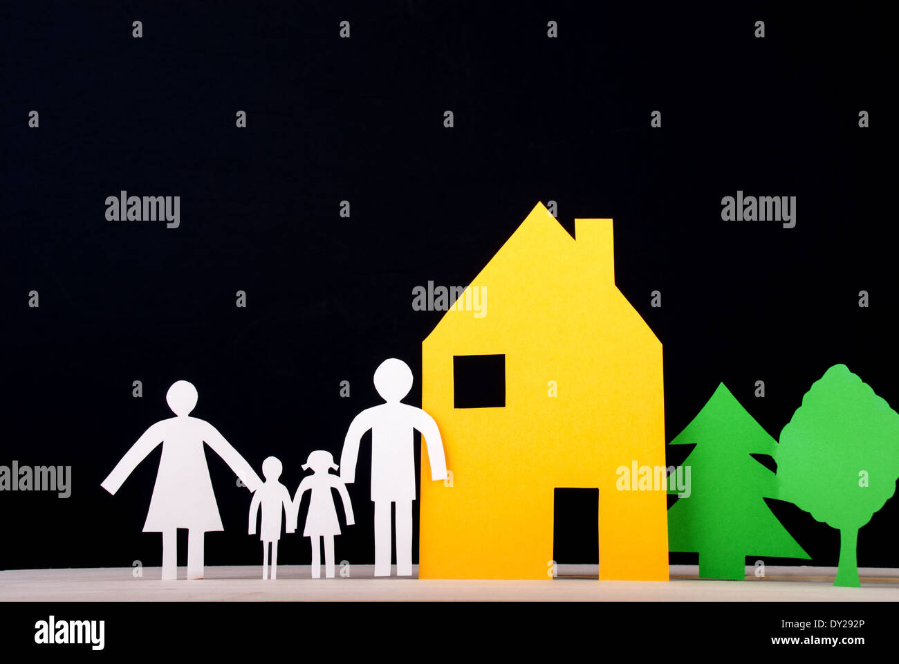 A Family in Front of their House with Trees beside, Paper Family Stock Photo