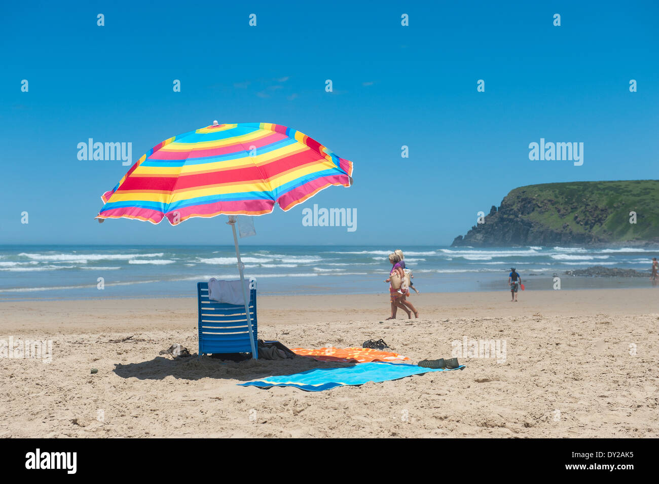 Sun umbrella and holidaymakers walking on the beach, Bay