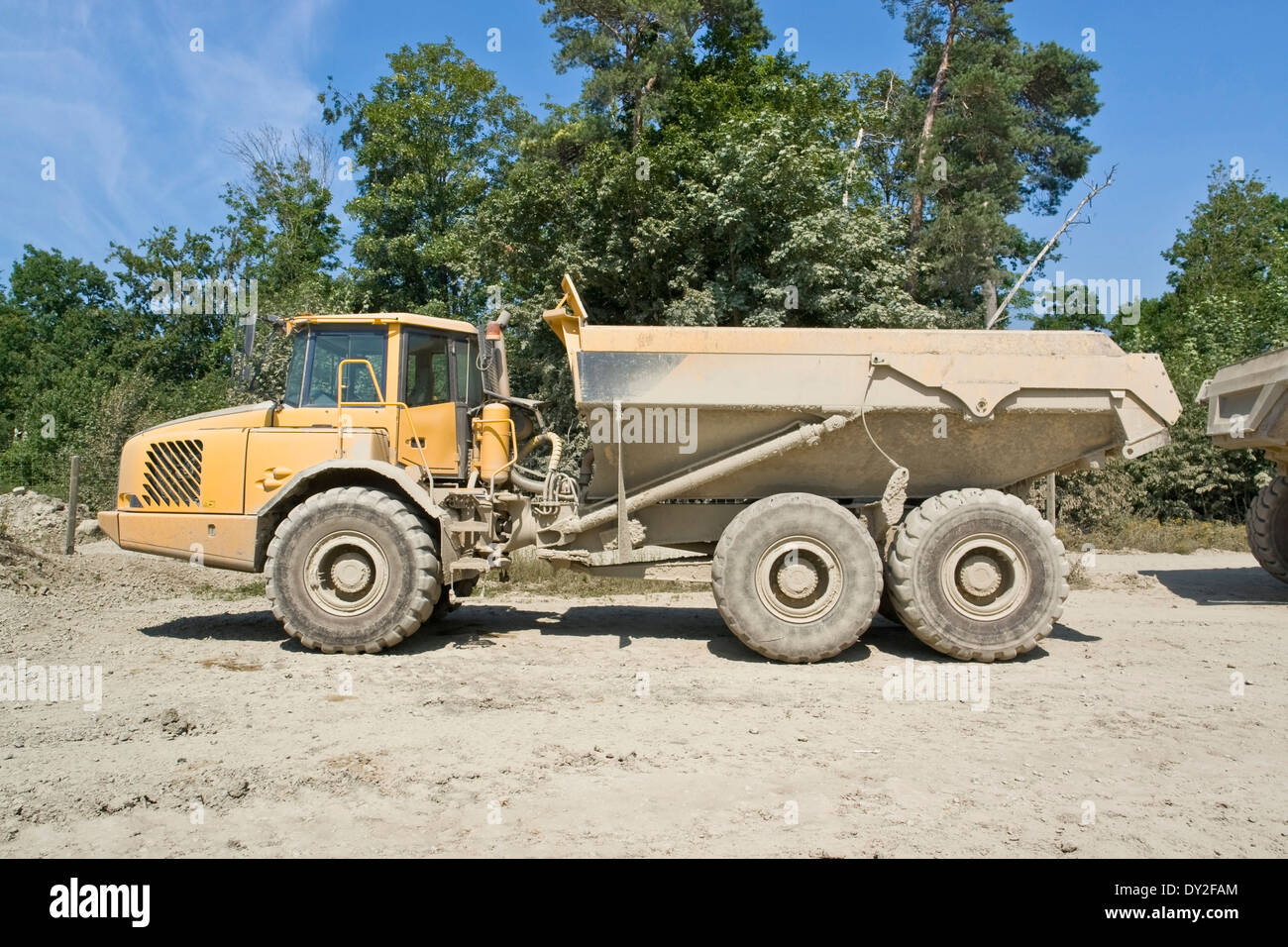 a yellow dirty dumper in sunny ambiance Stock Photo