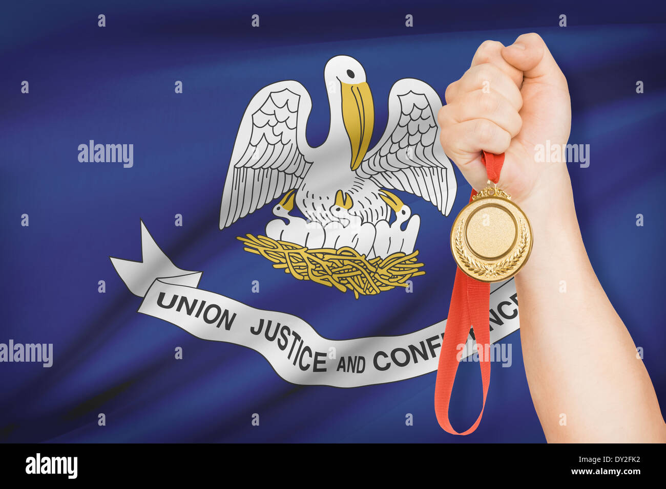 Sportsman holding gold medal with State of Louisiana flag on background. Part of a series. Stock Photo