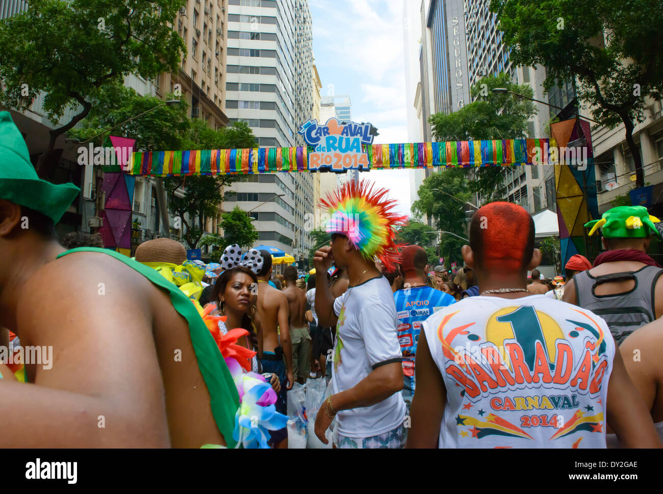 Rainbow head-dress amongst colourful crowds at street party, Carnival, Rio de Janeiro, 2014 Stock Photo