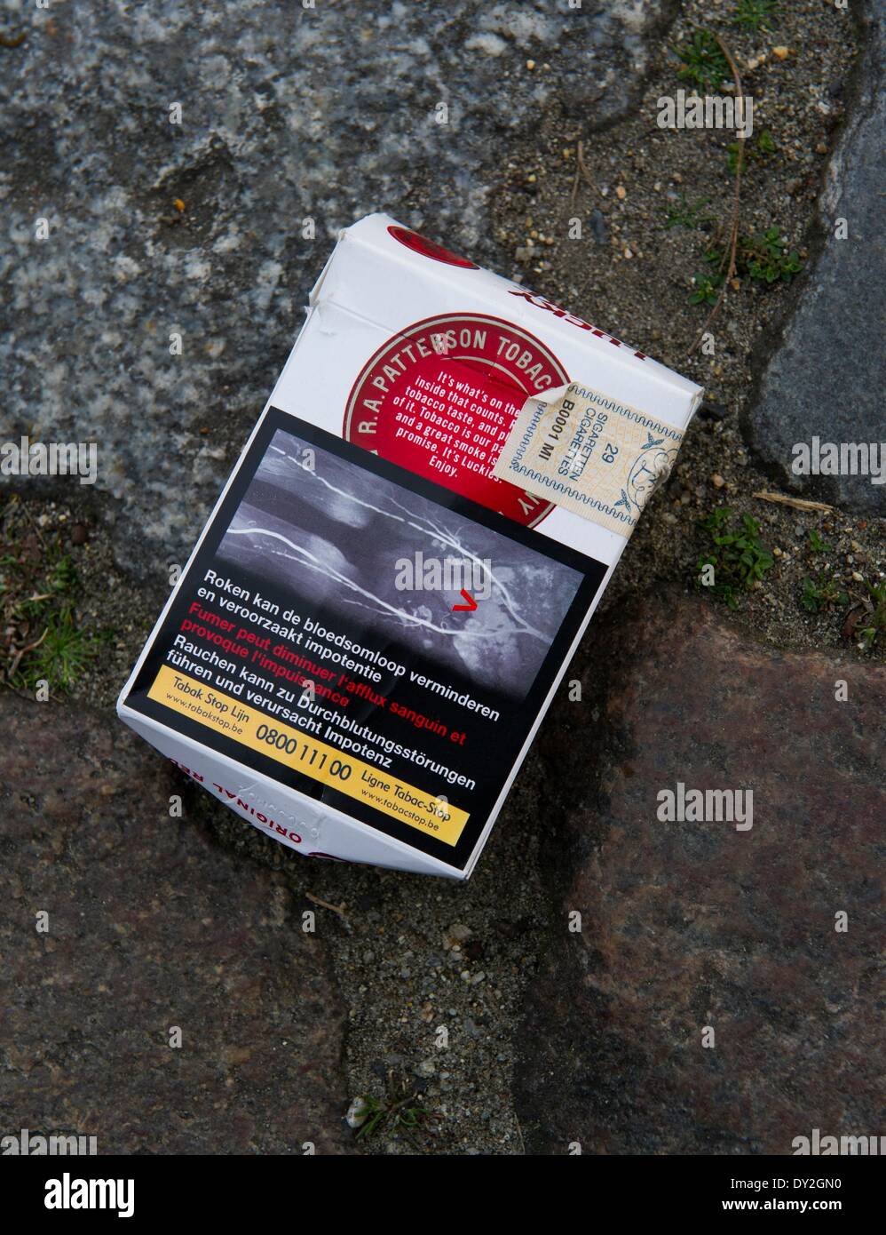 Berlin, Germany. 4th Apr, 2014. An empty package of cigarettes featuring  Dutch writing and a graphic warning depicting a blocked artery lies on the  ground in Berlin, Germany, 4 April 2014. Graphic