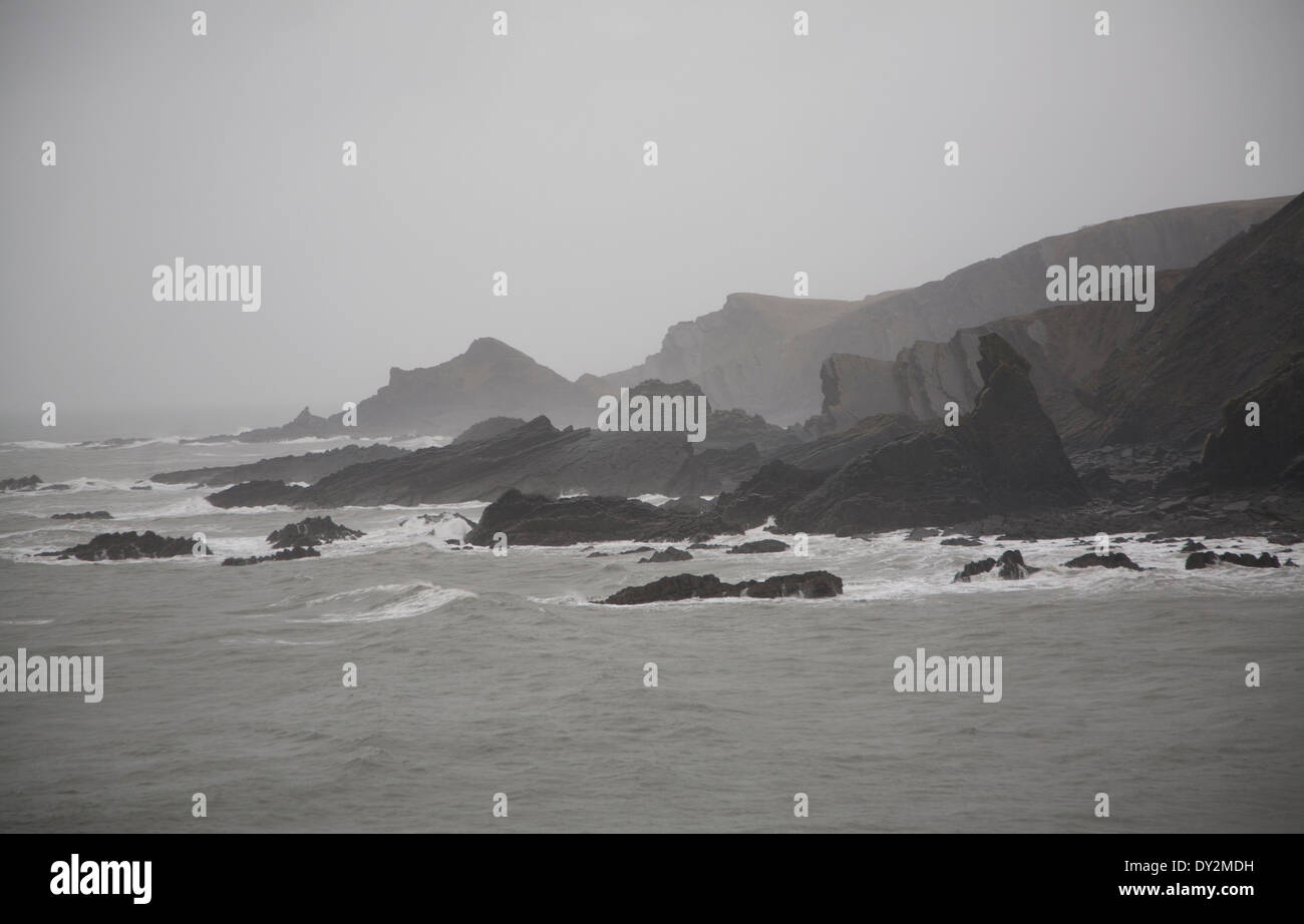 Large Atlantic storm waves crashing onto jagged rocky coast at Hartland Quay, north Devon, England Stock Photo