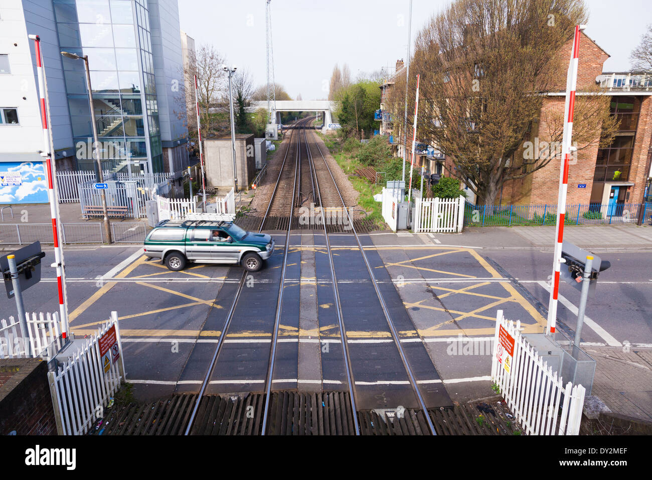 Looking down on railway level crossing with barriers up. Stock Photo