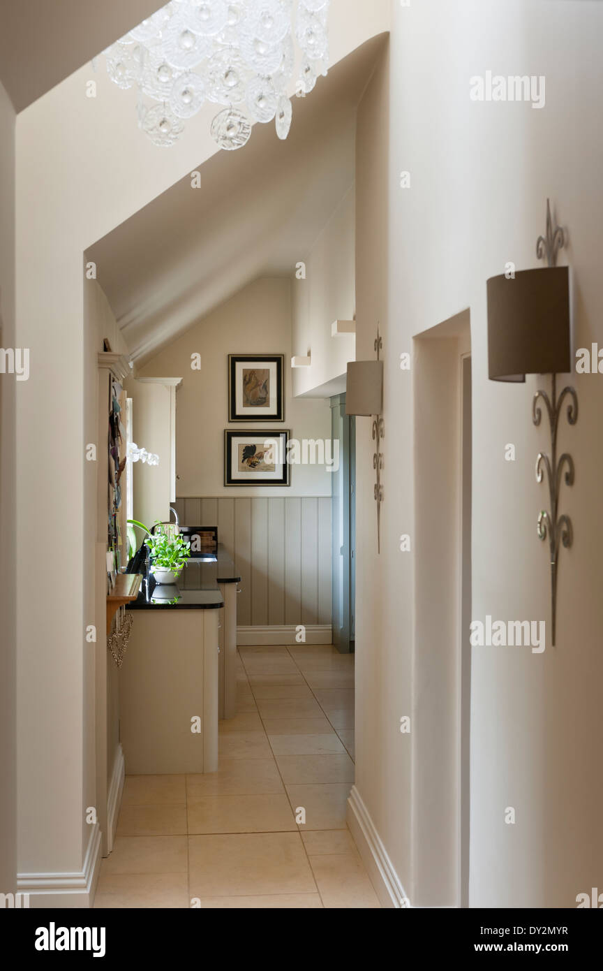 Corridor with slanted ceiling, glass chandelier and stylish wall sconces Stock Photo