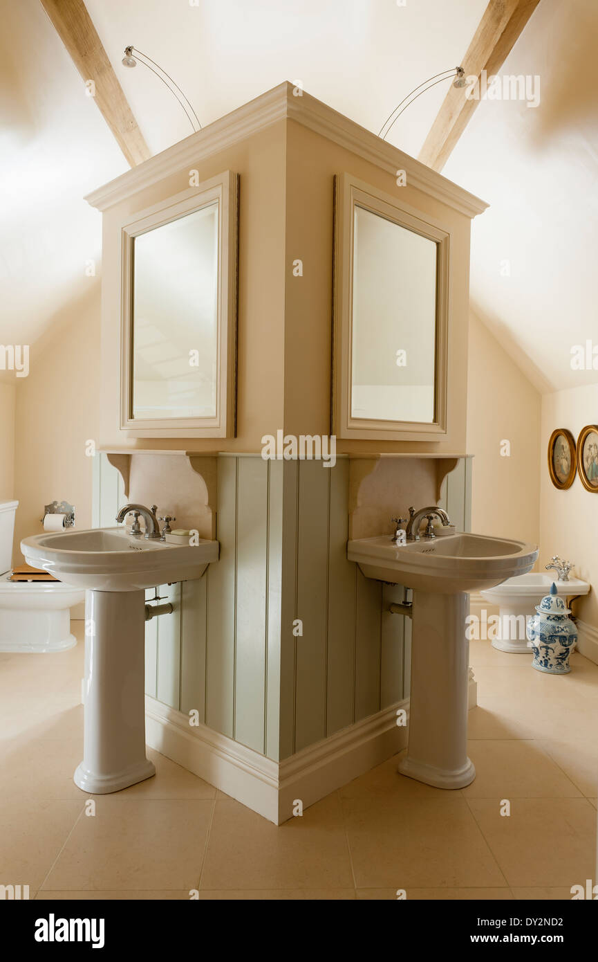 Twin basins behind central column in bathroom with mirrors Stock Photo