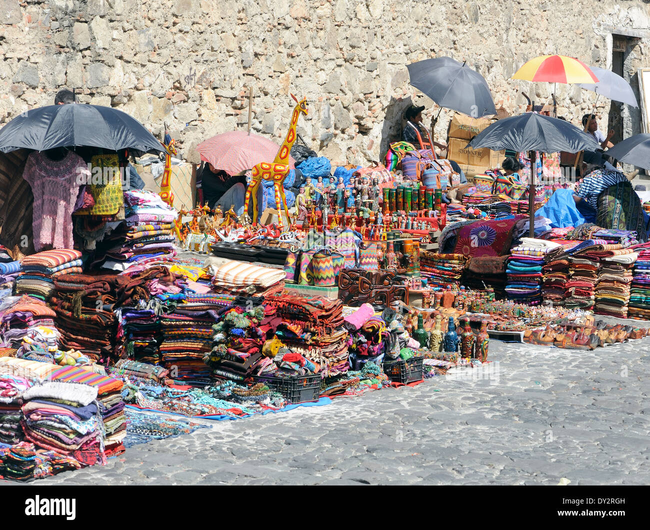 Sellers of crafts including woven goods and, strangely, giraffes.   Antigua Guatemala, Republic of Guatemala. Stock Photo