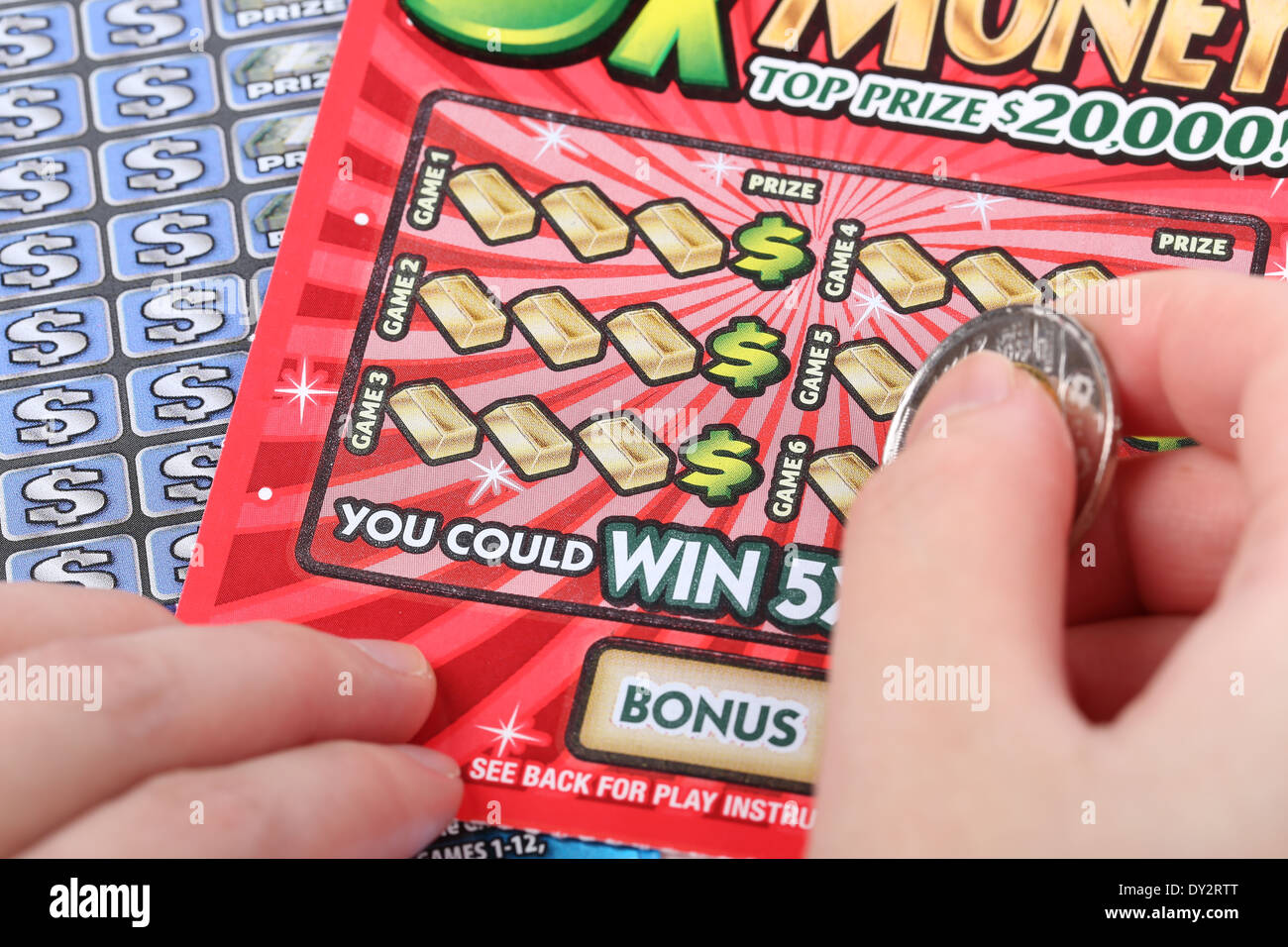 A human hand is scratching a lottery ticket Stock Photo