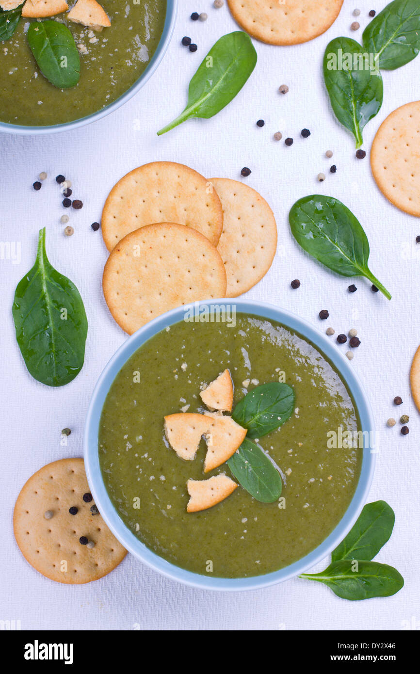 Spinach soup with crackers and black pepper shot from above Stock Photo