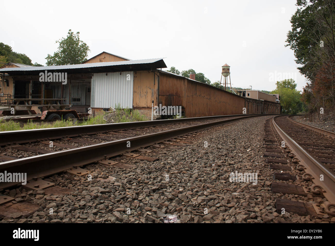 Railroad tracks swing past an aging manufacturing building in Chatham in upstate New York Stock