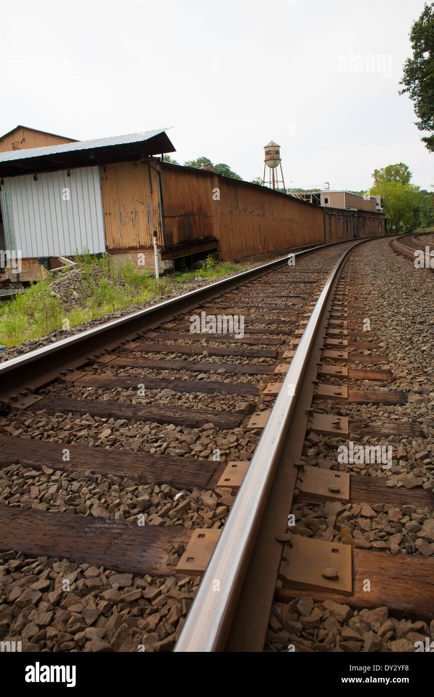 Railroad tracks swing past an aging manufacturing building in Chatham in upstate New York. Stock Photo