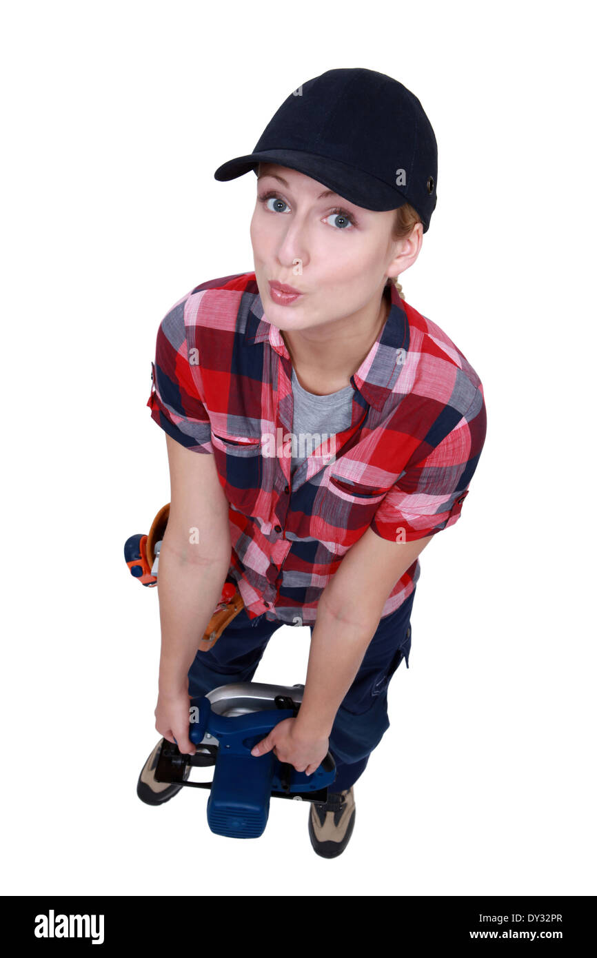 Blond worker struggling to carry circular saw Stock Photo Alamy