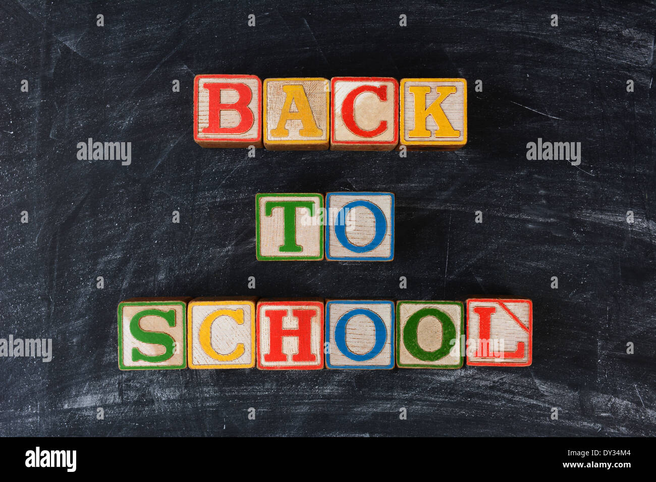 Childrens blocks spelling out Back To School on a chalk board. Horizontal format. Stock Photo