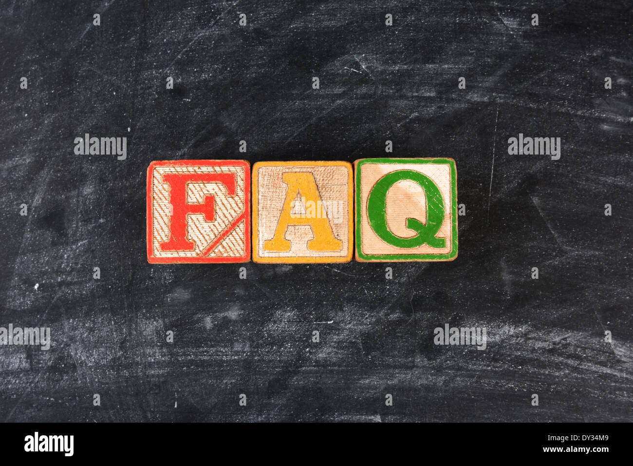 Colorful childrens blocks spelling out FAQ on a chalk board. Horizontal format. Stock Photo