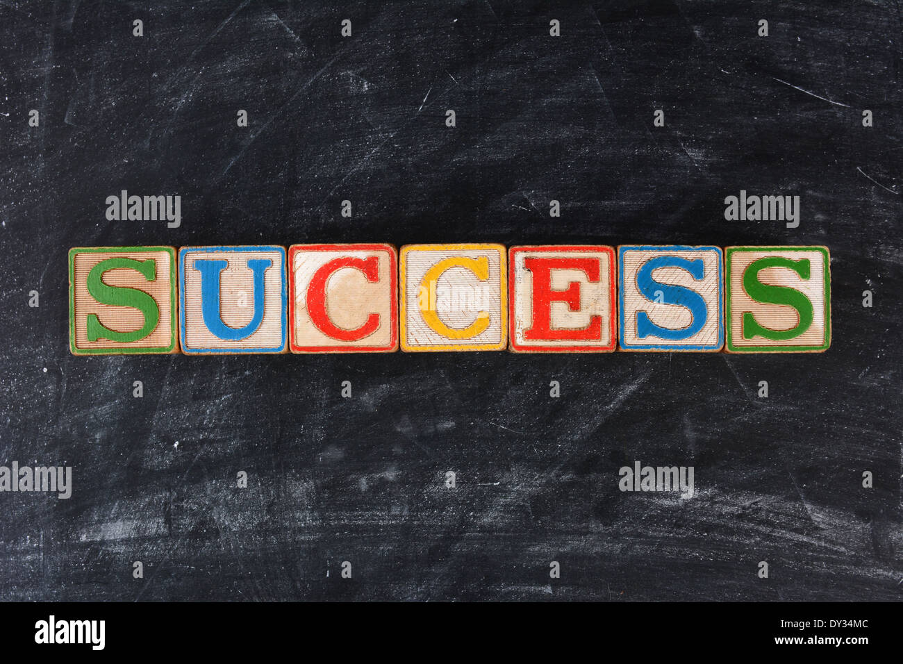 Colorful childrens blocks spelling out Success on a chalk board. Horizontal format. Stock Photo