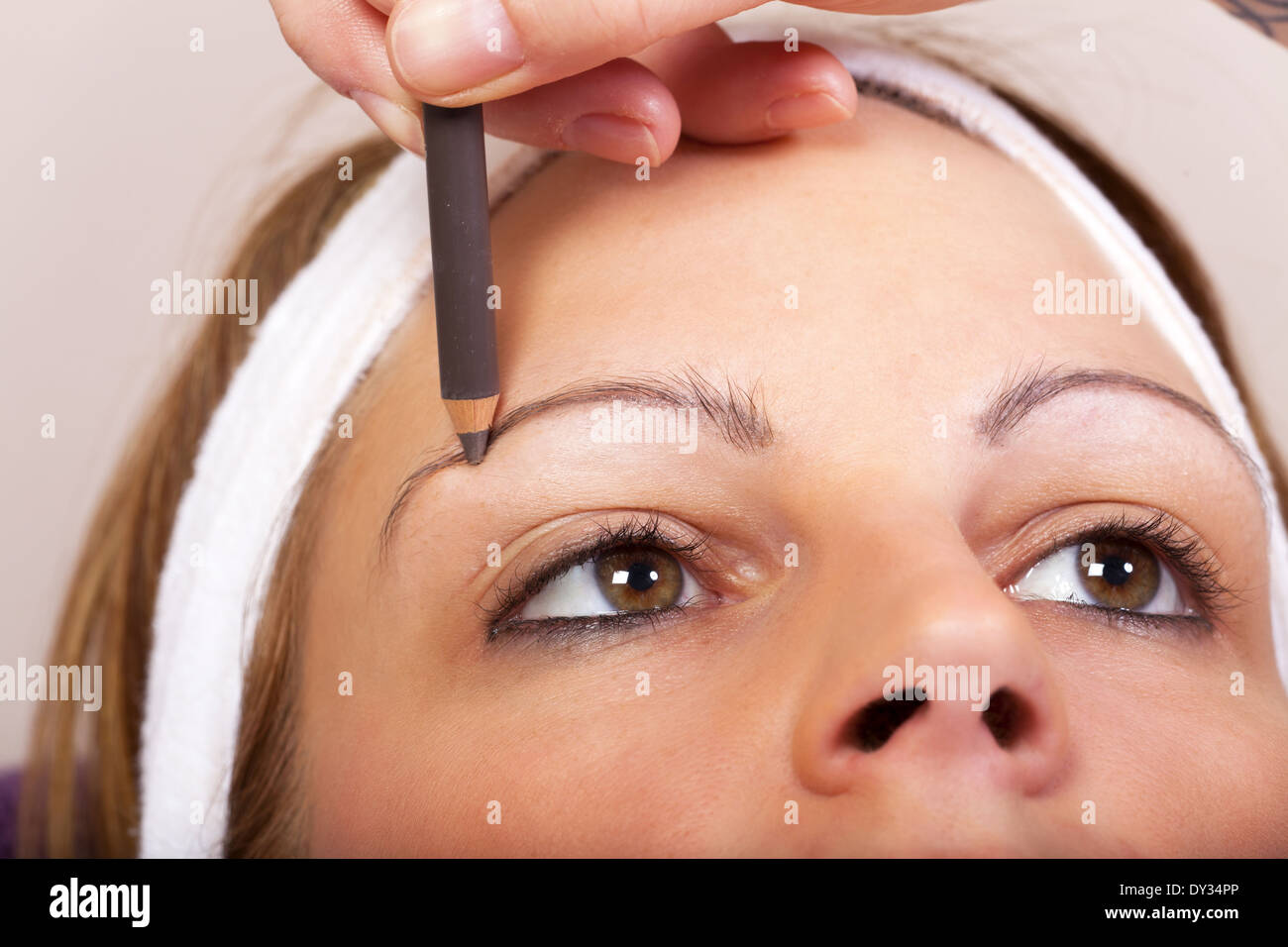 Beautician applying eyebrow pencil for darkening the Eyebrows of a