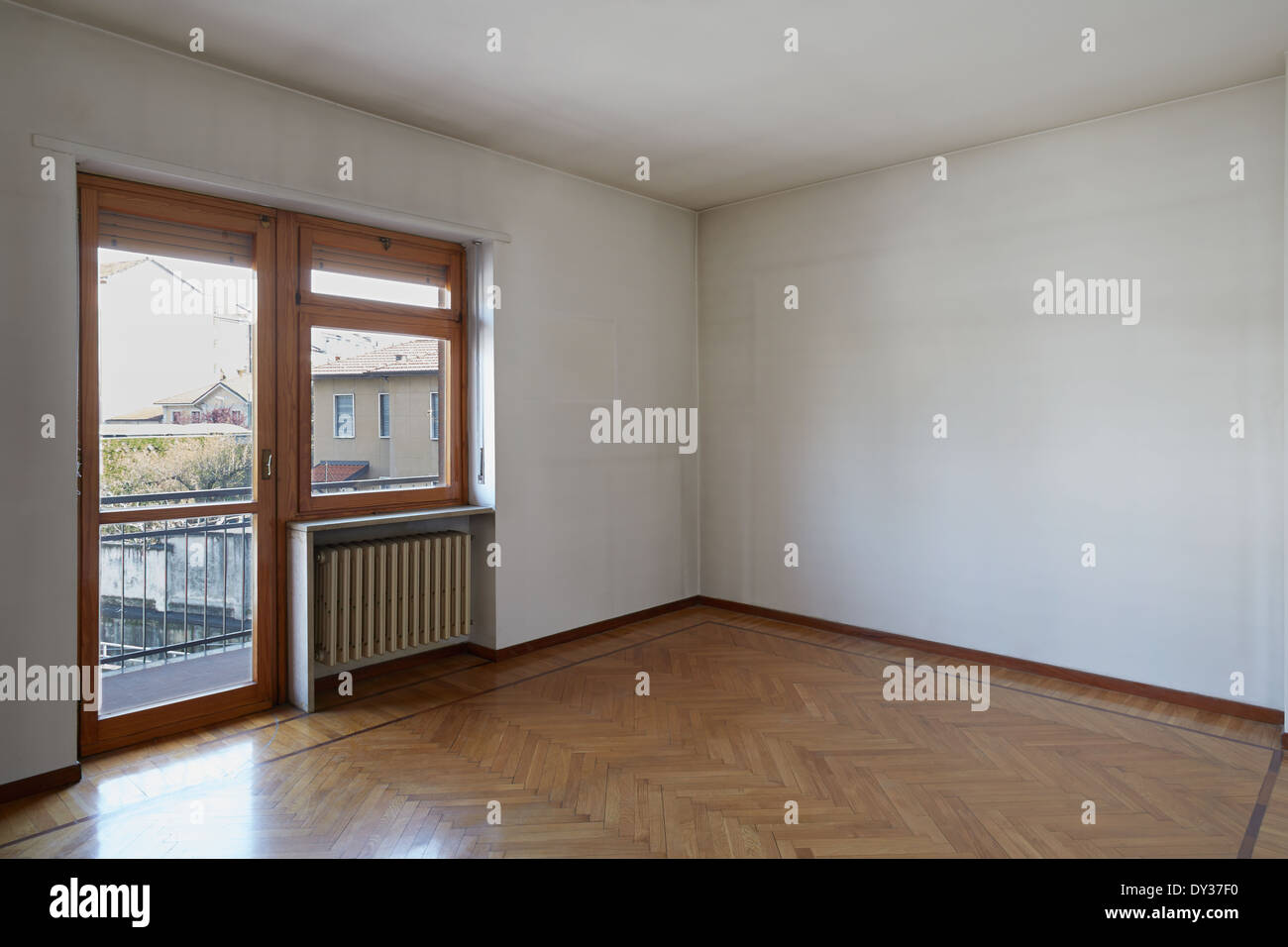 Empty room with wooden floor and dirty white walls Stock Photo