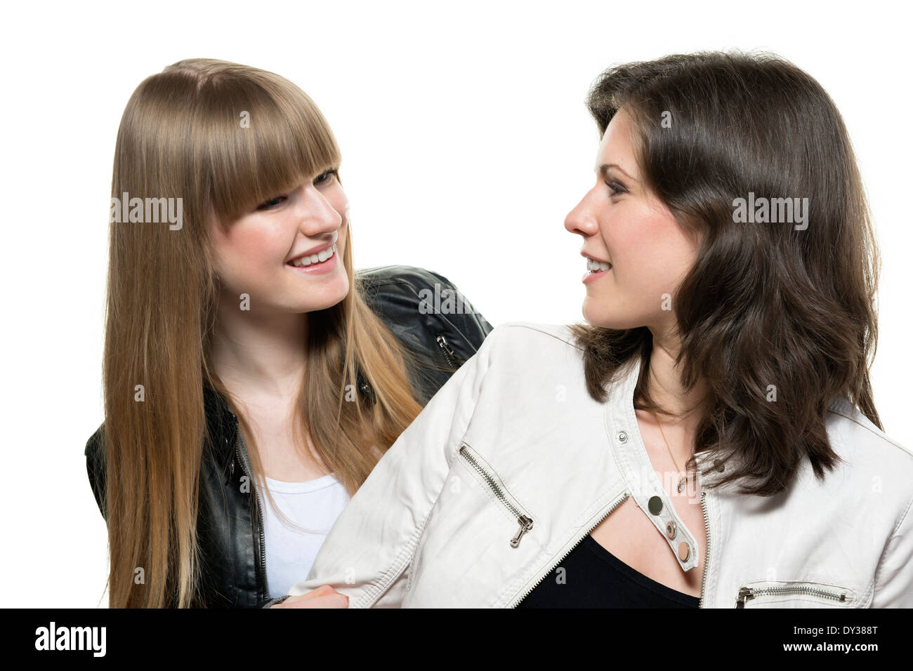 Two women blonde and brunette, with black and white leather jacket, look at each other Stock Photo