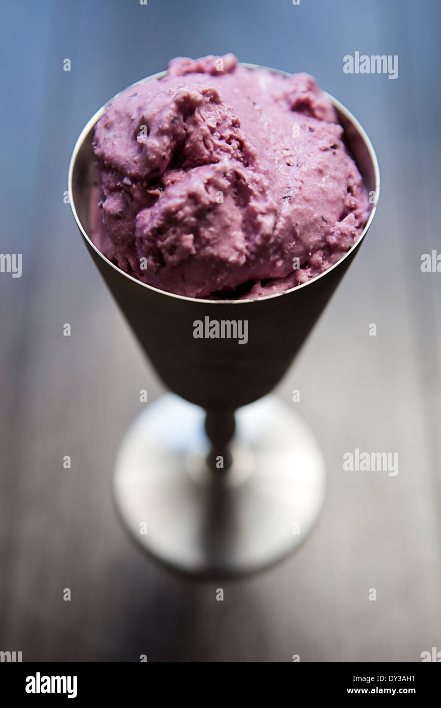Blueberry ice cream presented in a spun aluminium goblet. Stock Photo