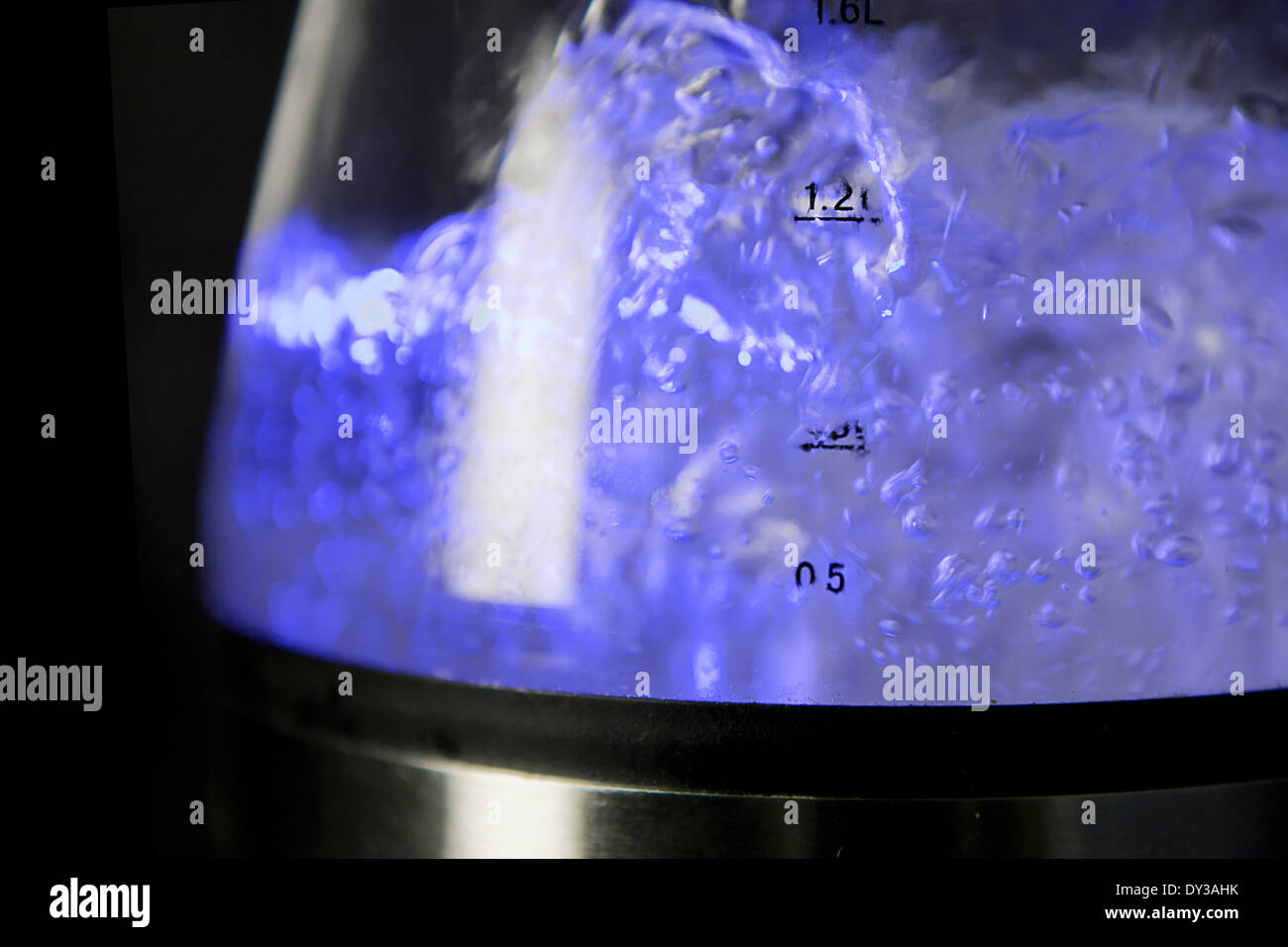 Close up of water boiling in a kettle lit internally by a blue LED Stock Photo