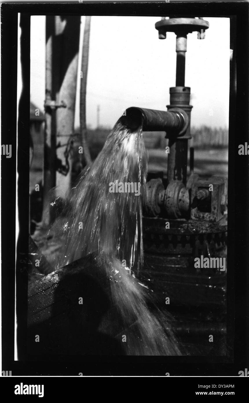 This image shows a close-up view of a new well, with water flowing from the source. It represents the installation of a well and the water supply system, important for providing clean water in rural or underserved areas. Stock Photo