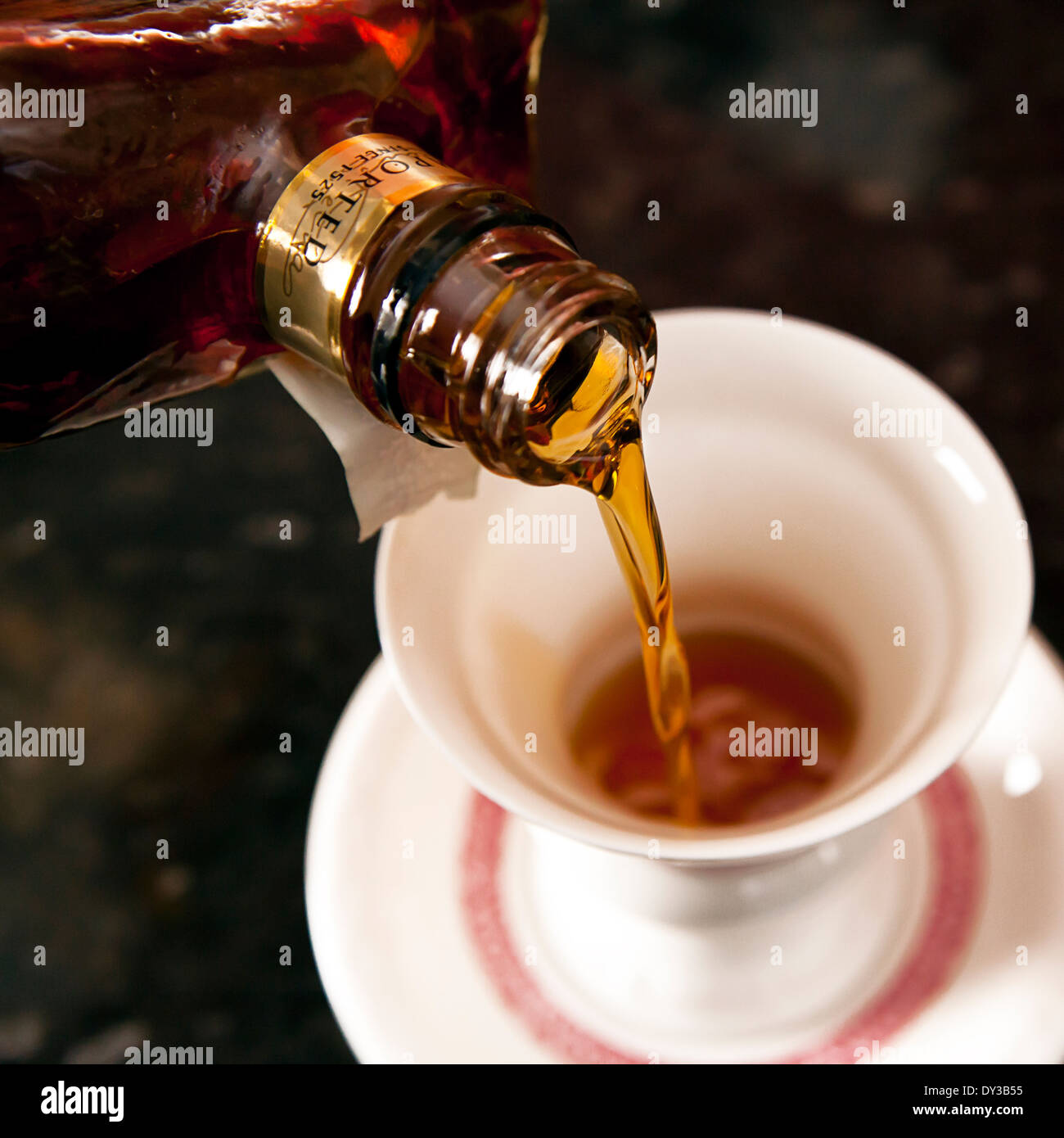 Liquor being poured into a traditional german coffee cup for a liquor coffee Stock Photo