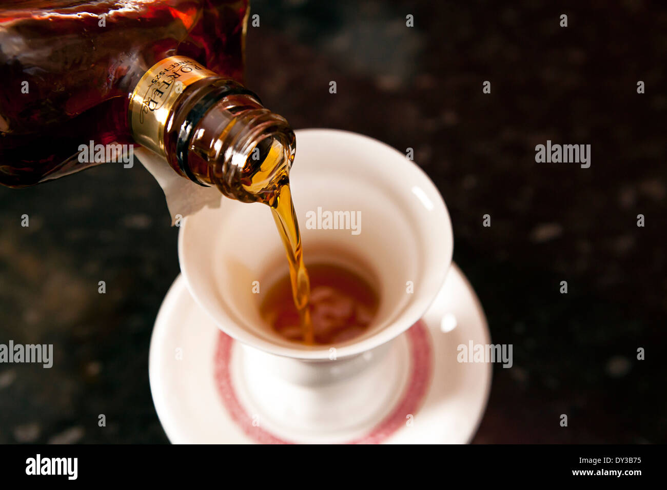 Liquor being poured into a traditional german coffee cup for a liquor