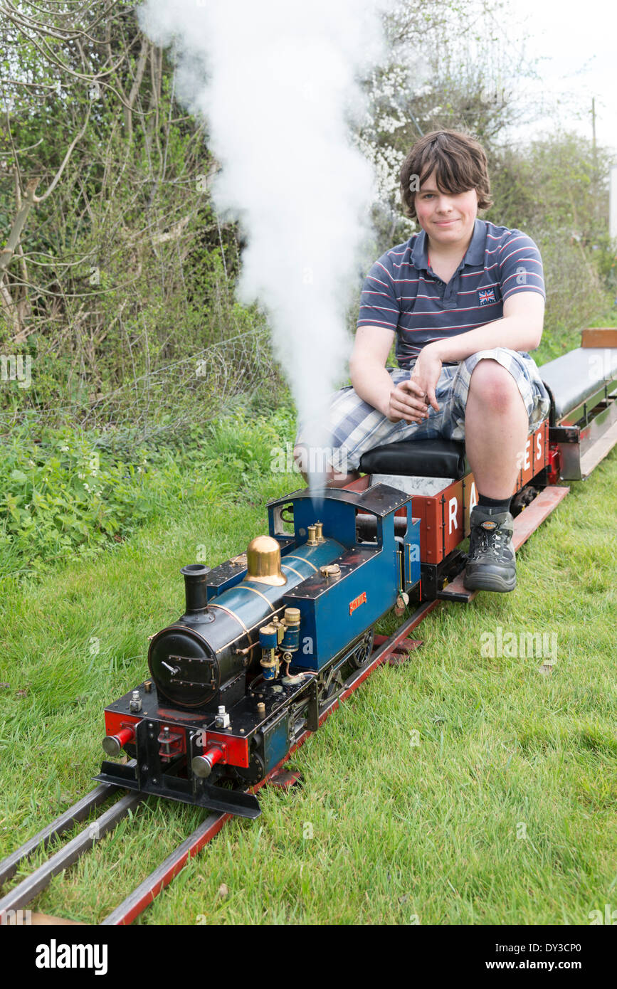 Thriplow, Cambridgeshire, UK. 5th April 2014. Visitors Tom Poskit prepares the steam train 'Cyril' for action as thousands of people enjoy spring sunshine at the Thriplow Daffodil Weekend in Cambridgeshire UK 5th April 2014. Each year between 7000-10000 people attend the village event to see displays of daffodils, visiting residents open gardens, craft barns, food stalls, Morris dancing, country craft demonstrations, heavy horses and fun fair rides. The roads are closed to traffic allowing visitors to wander the pretty village lanes in a celebration of spring. Credit:  Julian Eales/Alamy Live  Stock Photo