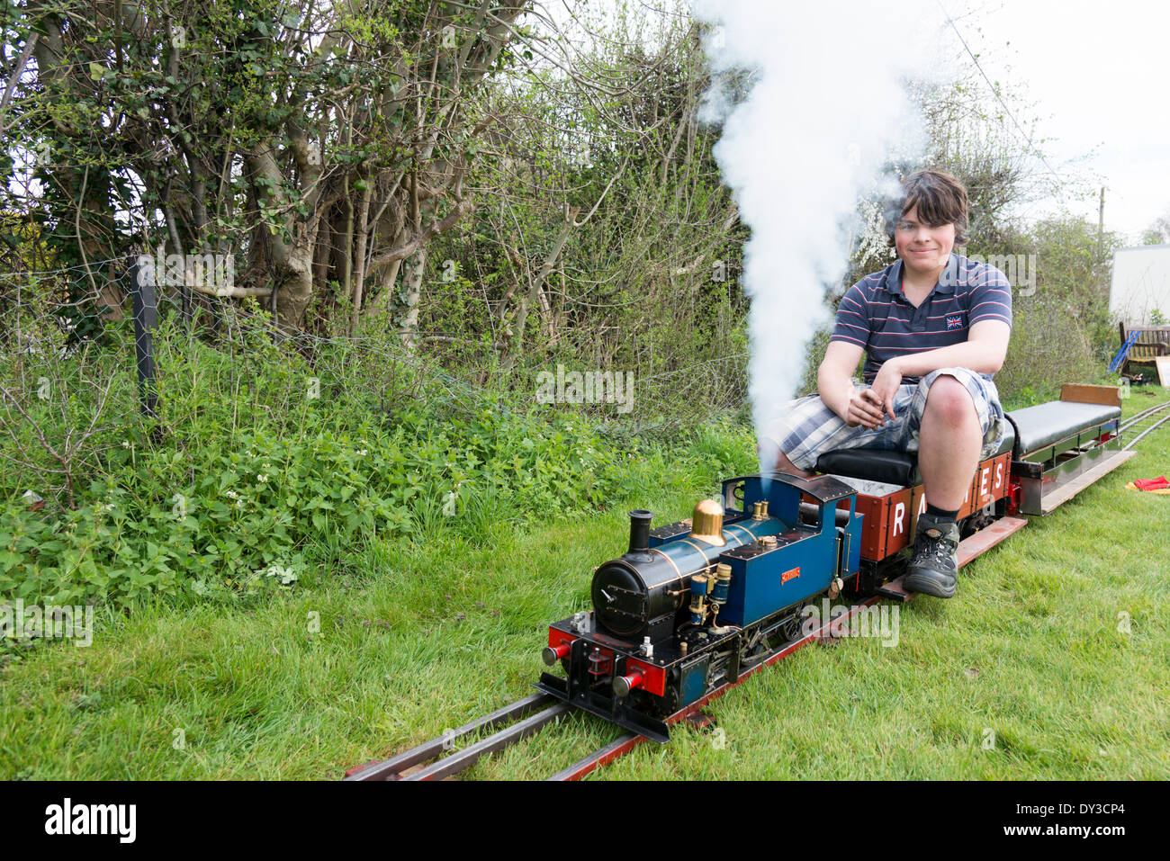 Thriplow, Cambridgeshire, UK. 5th April 2014. Visitors Tom Poskit prepares the steam train 'Cyril' for action as thousands of people enjoy spring sunshine at the Thriplow Daffodil Weekend in Cambridgeshire UK 5th April 2014. Each year between 7000-10000 people attend the village event to see displays of daffodils, visiting residents open gardens, craft barns, food stalls, Morris dancing, country craft demonstrations, heavy horses and fun fair rides. The roads are closed to traffic allowing visitors to wander the pretty village lanes in a celebration of spring. Credit:  Julian Eales/Alamy Live  Stock Photo