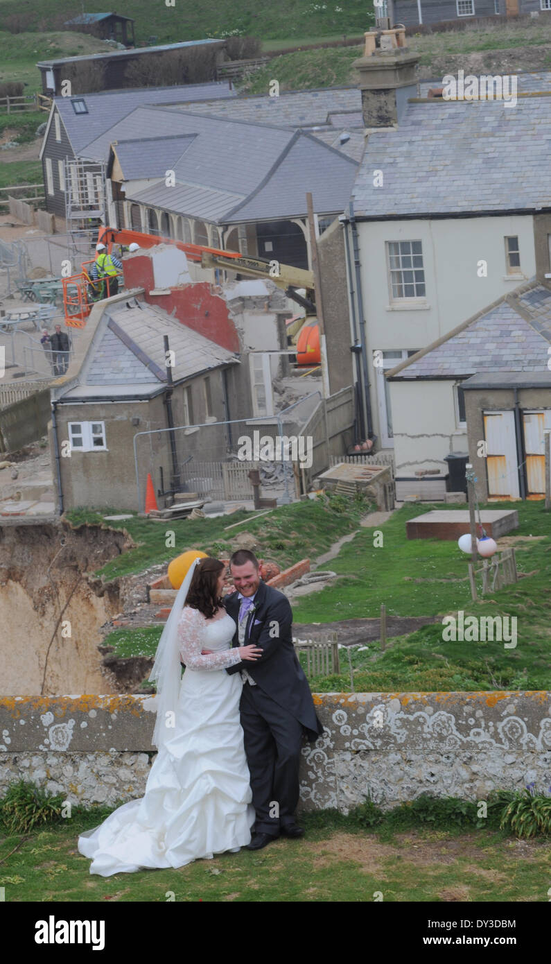Birling Gap, East Sussex, UK. 5 April 2014. Newly weds Mr and Mrs Farrer from Hassleworth pose in front of the coastguard cottages at the East Sussex beauty spot. A Happy start in front of a sad ending for cottage no3.David Burr/Alamy Live News Stock Photo