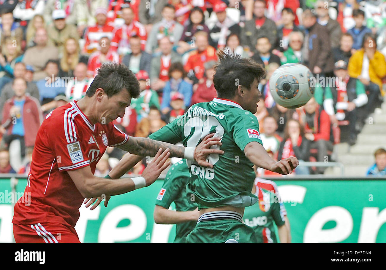 Augsburg, Germany. 05th Apr, 2014. Augsburg's Jeong-Ho Hong (R) and Mario Mandzukic vie for the ball during the Bundesliga Soccer match between FC Augsburg and FC Bayern Munich at the SGL-Arena in Augsburg, Germany, 05 April 2014. Photo: Stefan Puchner/dpa (ATTENTION: Due to the accreditation guidelines, the DFL only permits the publication and utilisation of up to 15 pictures per match on the internet and in online media during the match.)/dpa/Alamy Live News Stock Photo