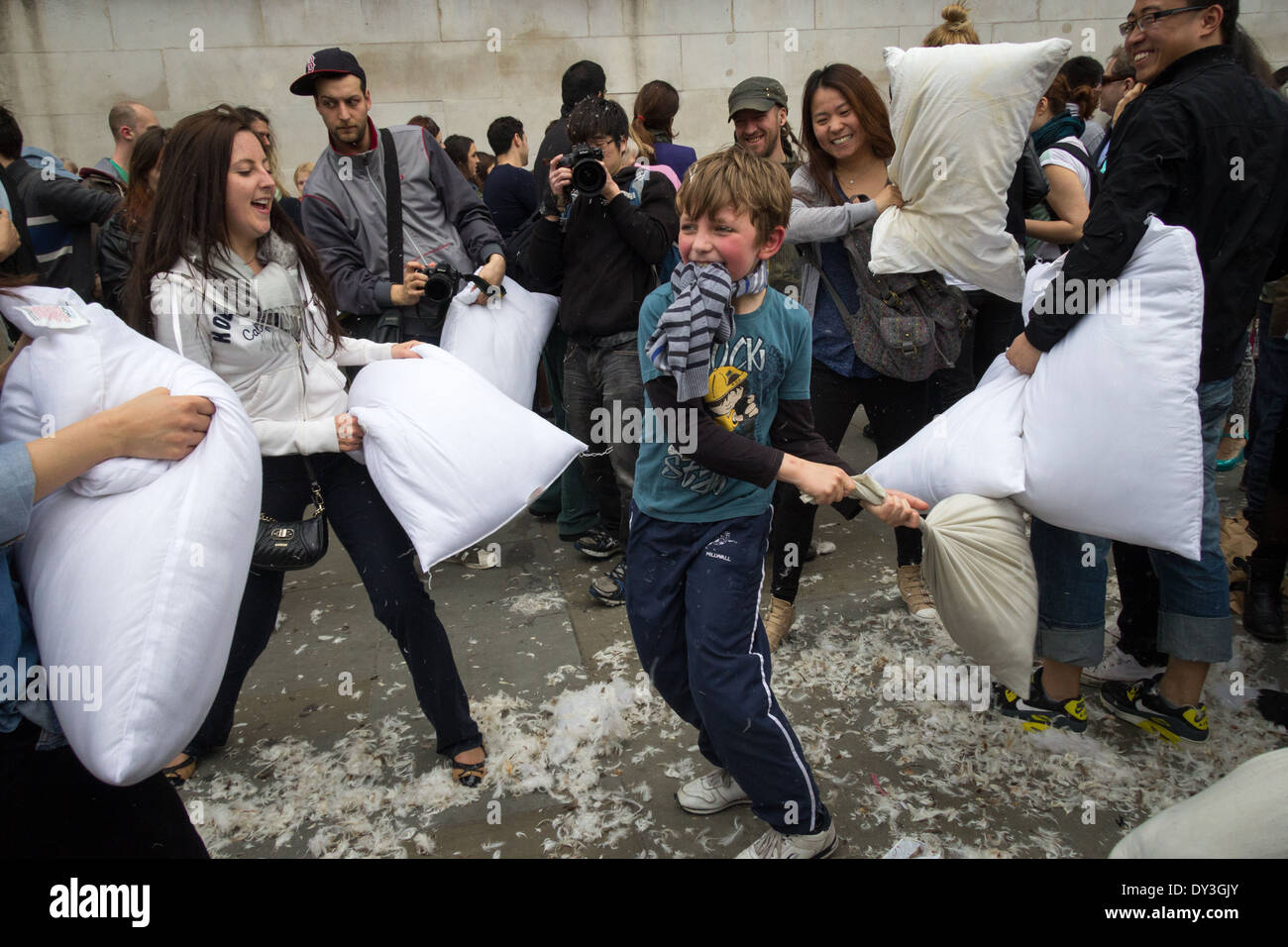 A young child hits a series of people during the pillow fight. Stock Photo