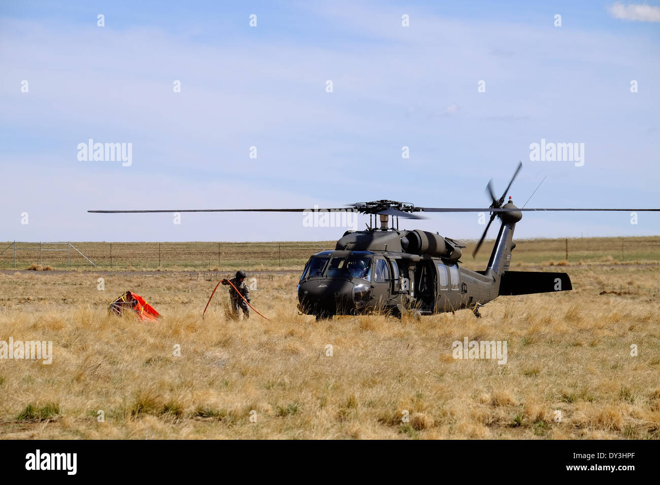 Commerce City, Colorado USA - 5th April 2014. Members of the Colorado National Guard 2nd Battalion, 135th General Support Aviation Brigade based out of Buckley Air Force Base in Aurora, Colorado land their helicopter after practicing their communication and bucket drop techniques at The Rocky Mountain Arsenal National Wildlife Refuge in preparation for Colorado’s upcoming fire season. This is the first year that firefighters on the ground are able to communicate with those in the air to coordinate the firefighting effort. Credit:  Ed Endicott/Alamy Live News Stock Photo