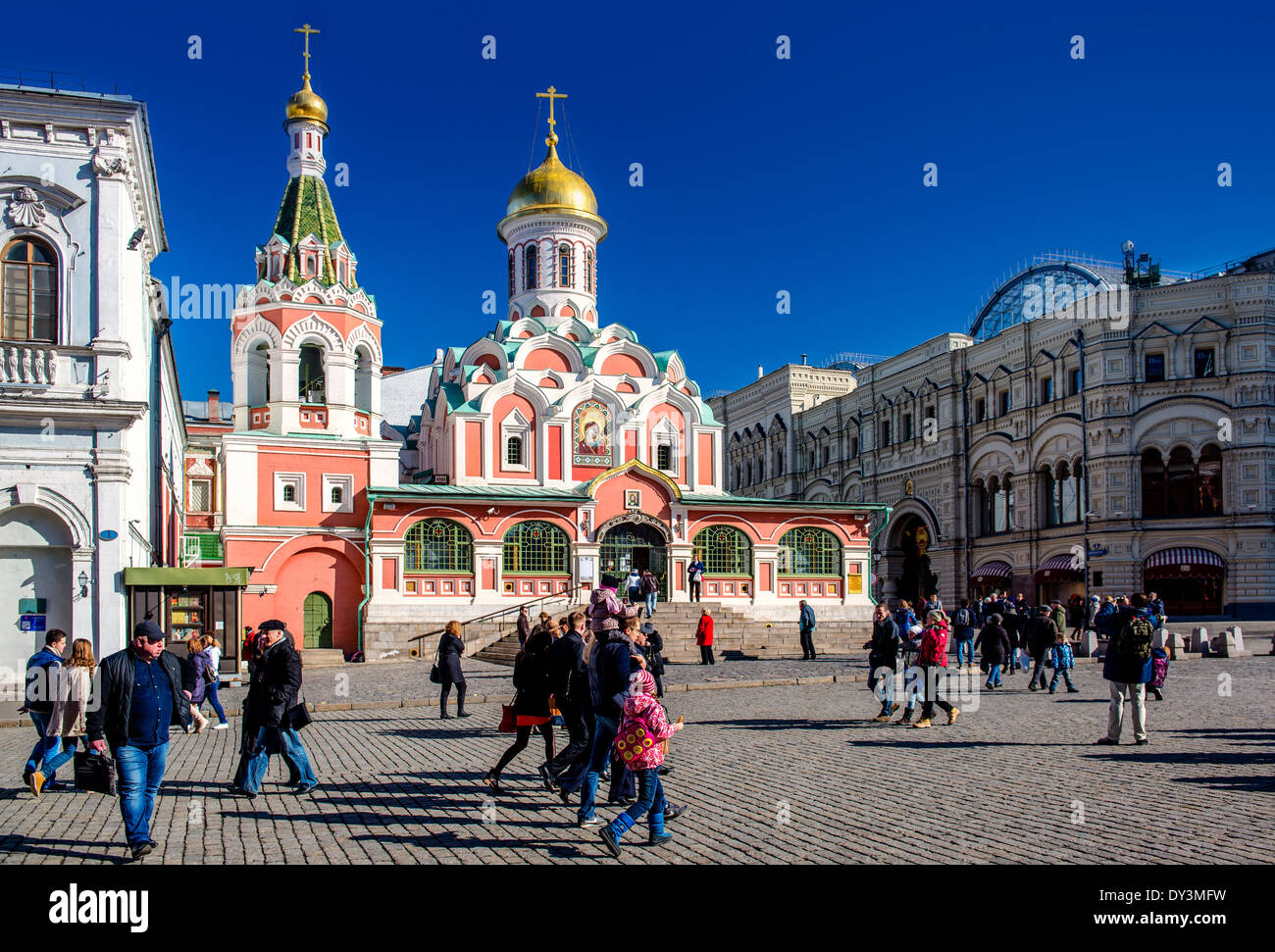 A crowd of people walking on Red Square. View of Kazan Cathedral and GUM Trading House Stock Photo