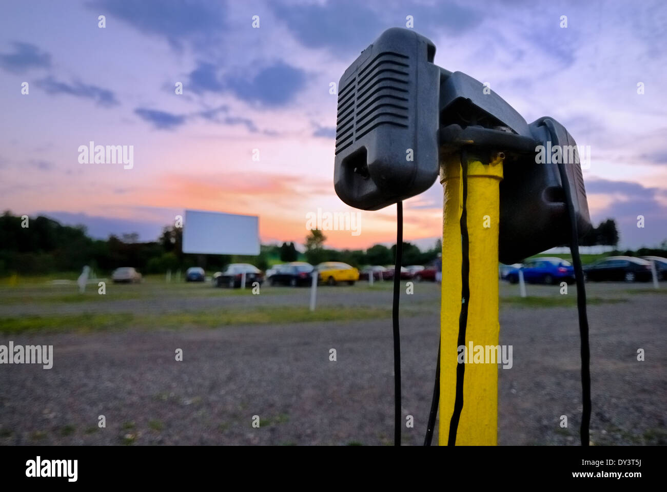 Car speakers in the foreground in this image, taken at dusk, at the Dependable Drive In located in Moon Township, Pennsylvania. Stock Photo