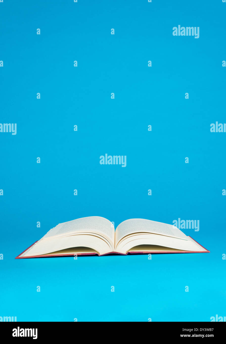 An open book on a bright blue background Stock Photo