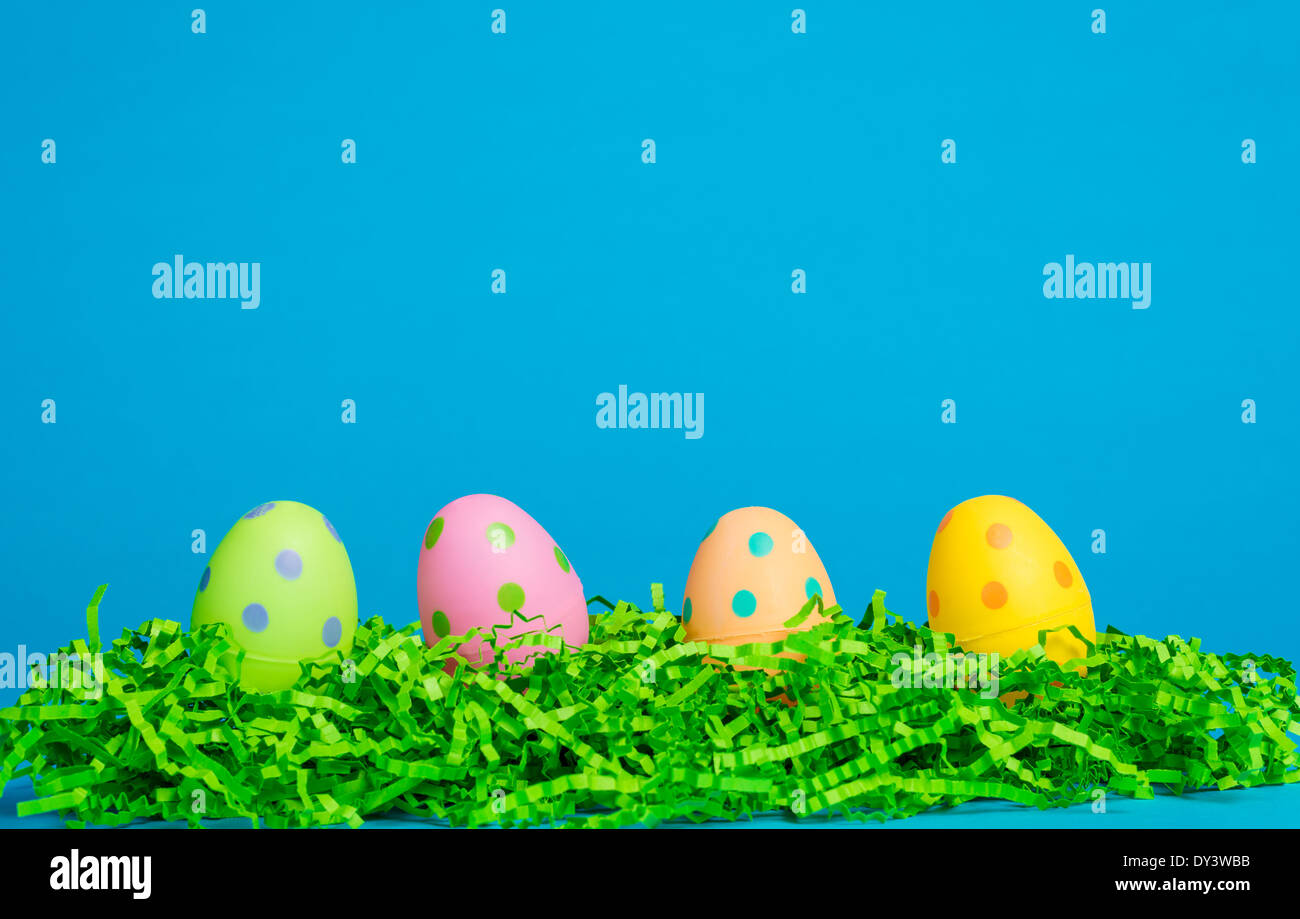 4 assorted colored Easter eggs on a sky blue background Stock Photo