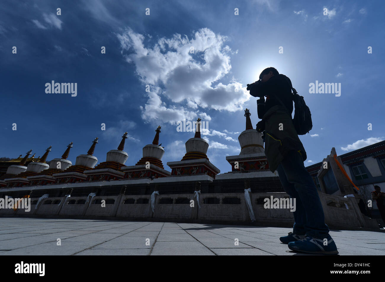 Huangzhong County, China's Qinghai Province. 6th Apr, 2014. A tourist taks photos in the Kumbum Monastery in Huangzhong County of Xining, capital of northwest China's Qinghai Province, April 6, 2014. The Kumbum Monastery is a main destination for Tibetan Buddhist pilgrims. It is also a major tourist attraction in Qinghai, which features splendid religious murals, Thangka appliques and butter sculptures. © Wu Gang/Xinhua/Alamy Live News Stock Photo