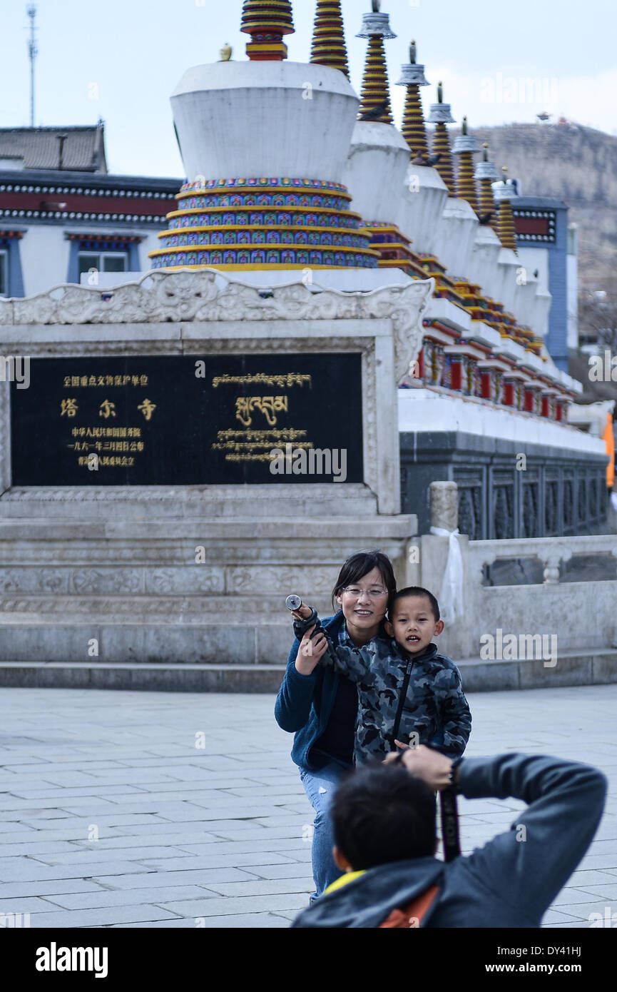 Huangzhong County, China's Qinghai Province. 6th Apr, 2014. Two tourists pose for photos in the Kumbum Monastery in Huangzhong County of Xining, capital of northwest China's Qinghai Province, April 6, 2014. The Kumbum Monastery is a main destination for Tibetan Buddhist pilgrims. It is also a major tourist attraction in Qinghai, which features splendid religious murals, Thangka appliques and butter sculptures. © Wu Gang/Xinhua/Alamy Live News Stock Photo
