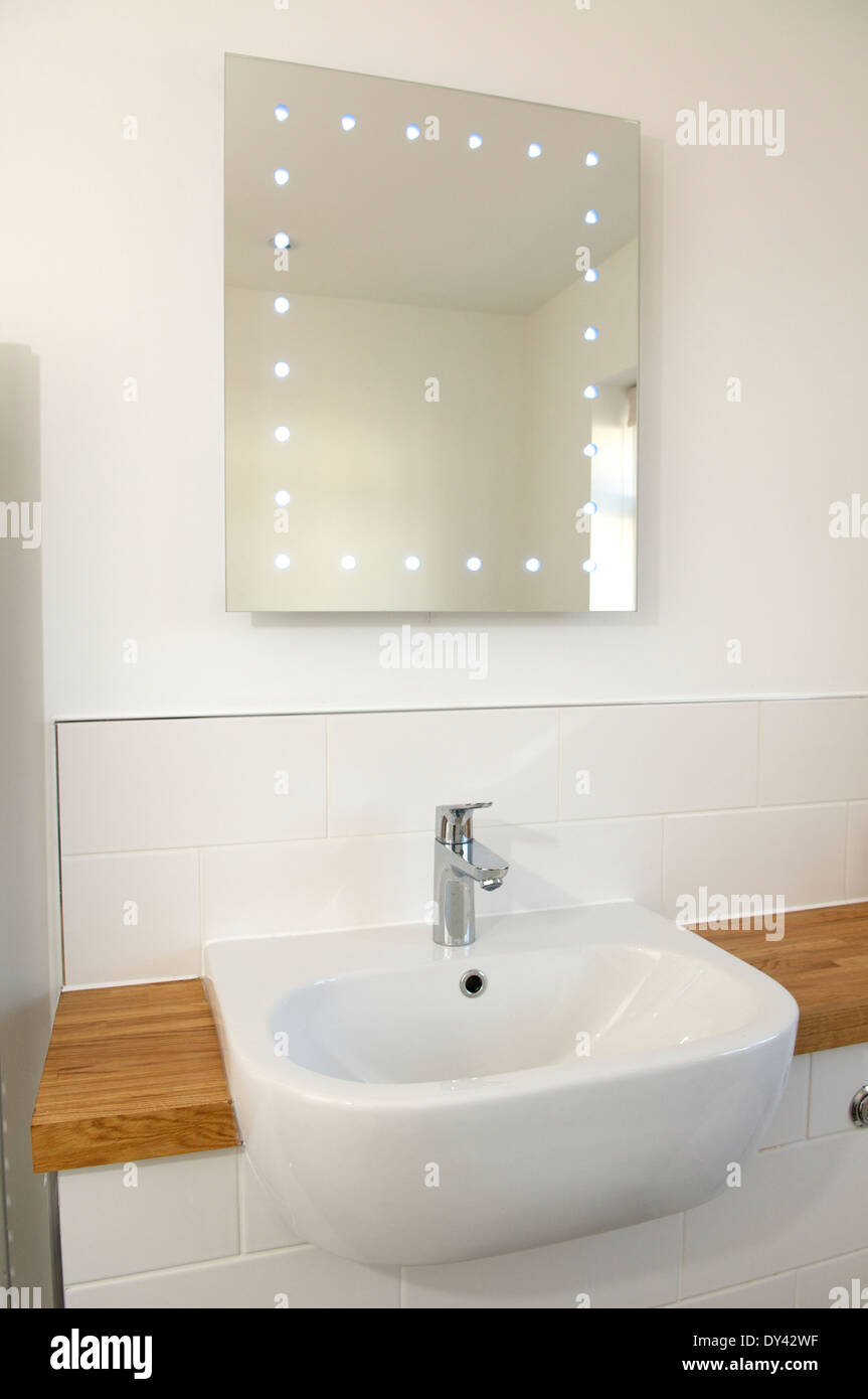 Modern bathroom sink and illuminated mirror Stock Photo