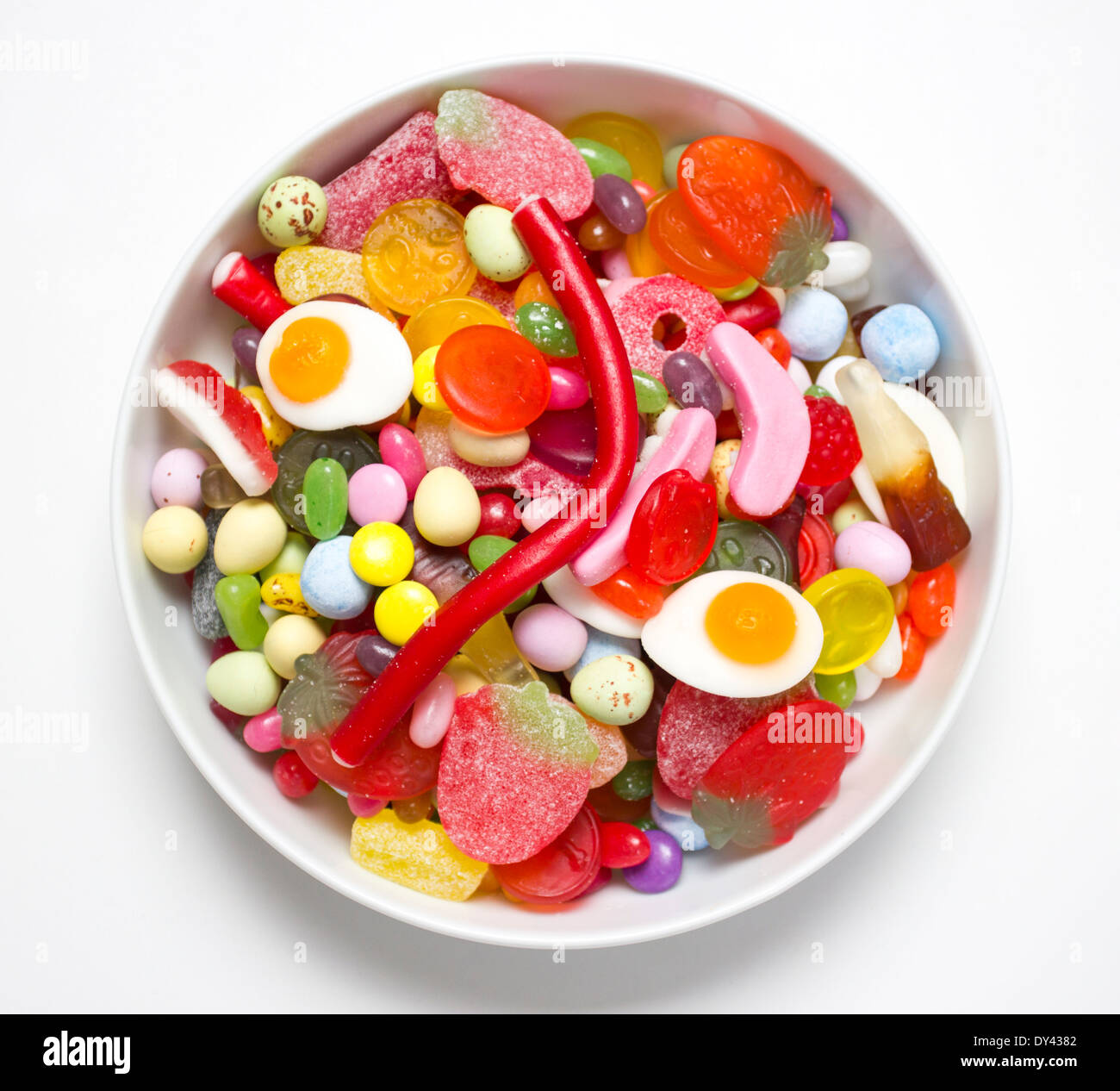 A white bowl full of colourful pick and mix sweets Stock Photo