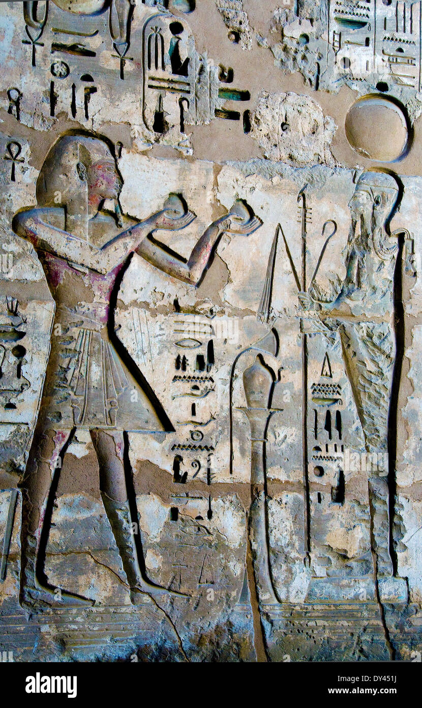 Temple of Ramses III at Medinet Habu: reliefs on the walls of the first courtyard. The king offering to god Kons. Stock Photo