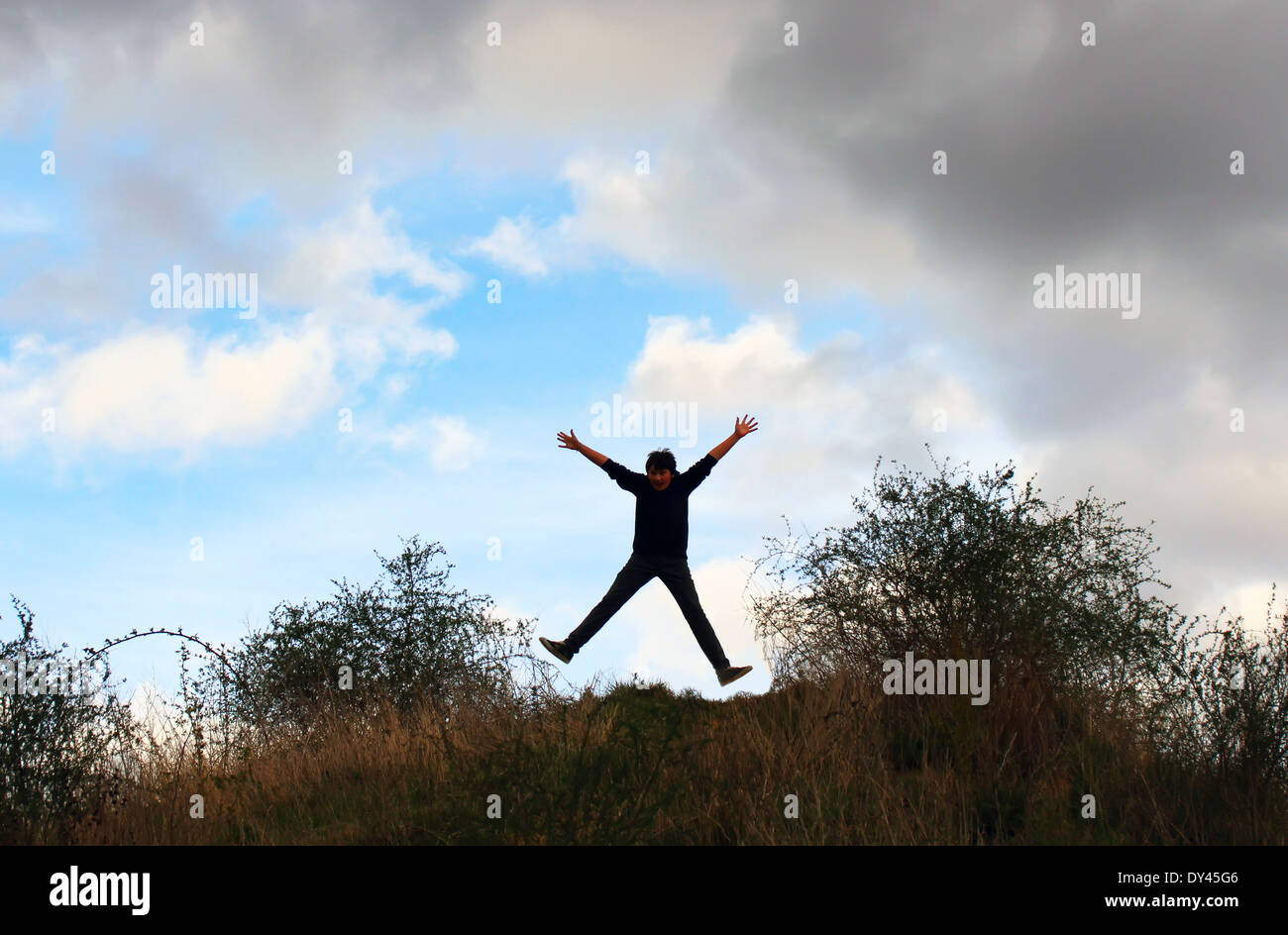 Photo of boy jumping and raising hands up Stock Photo - Alamy