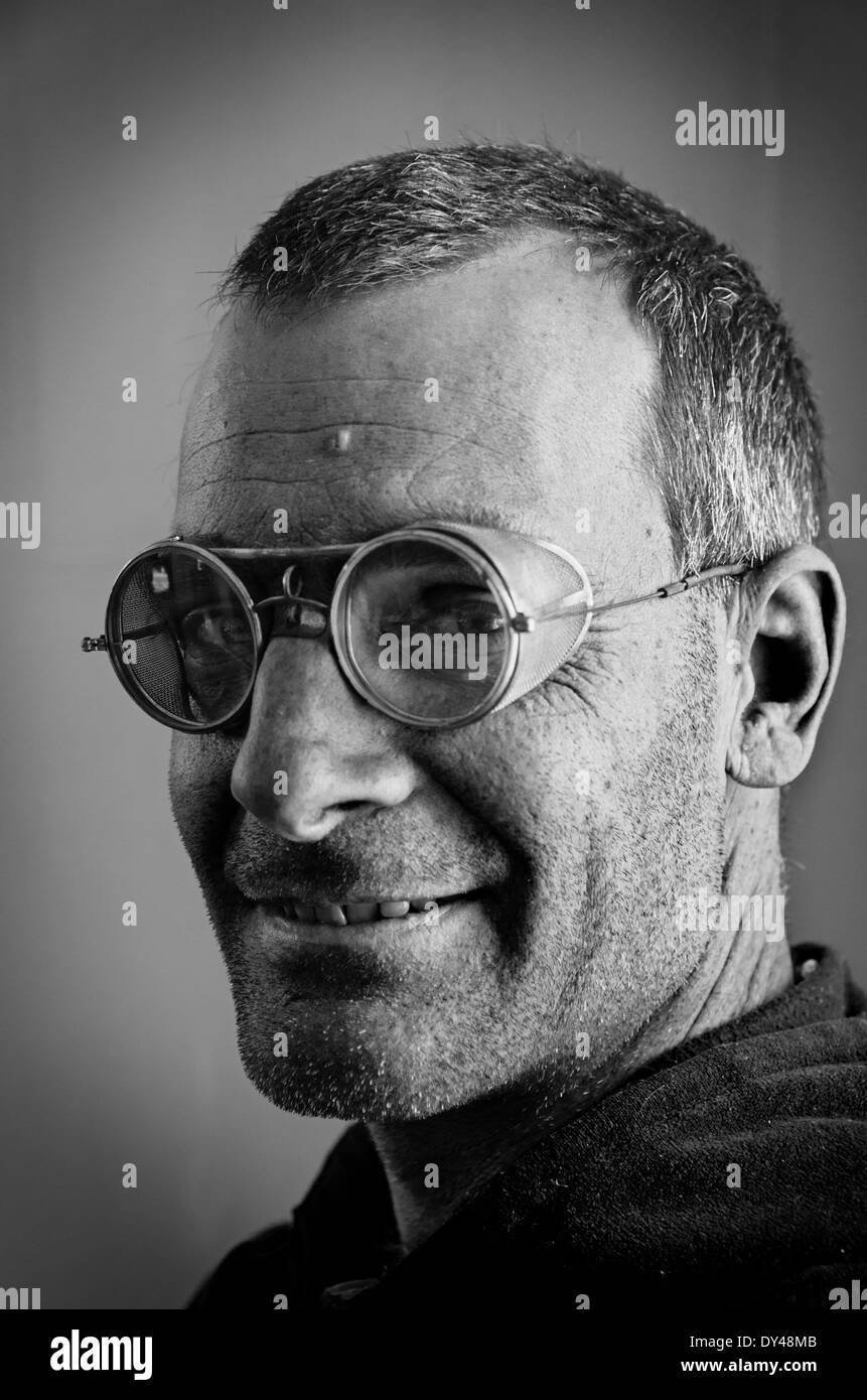 black and white image of man with steampunk style old safety glasses with mesh side shields Stock Photo