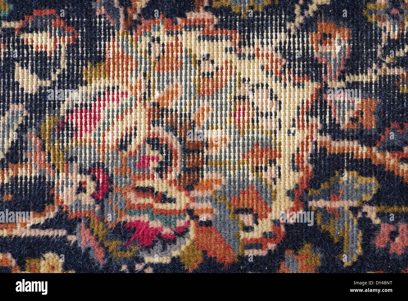 threadbare old persian carpet background detail Stock Photo