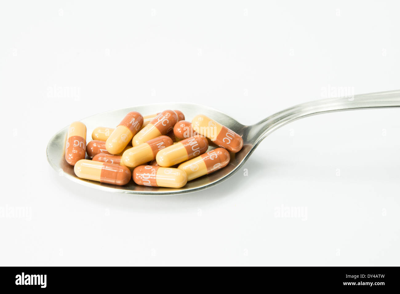 spoon full of white pills on the table Stock Photo
